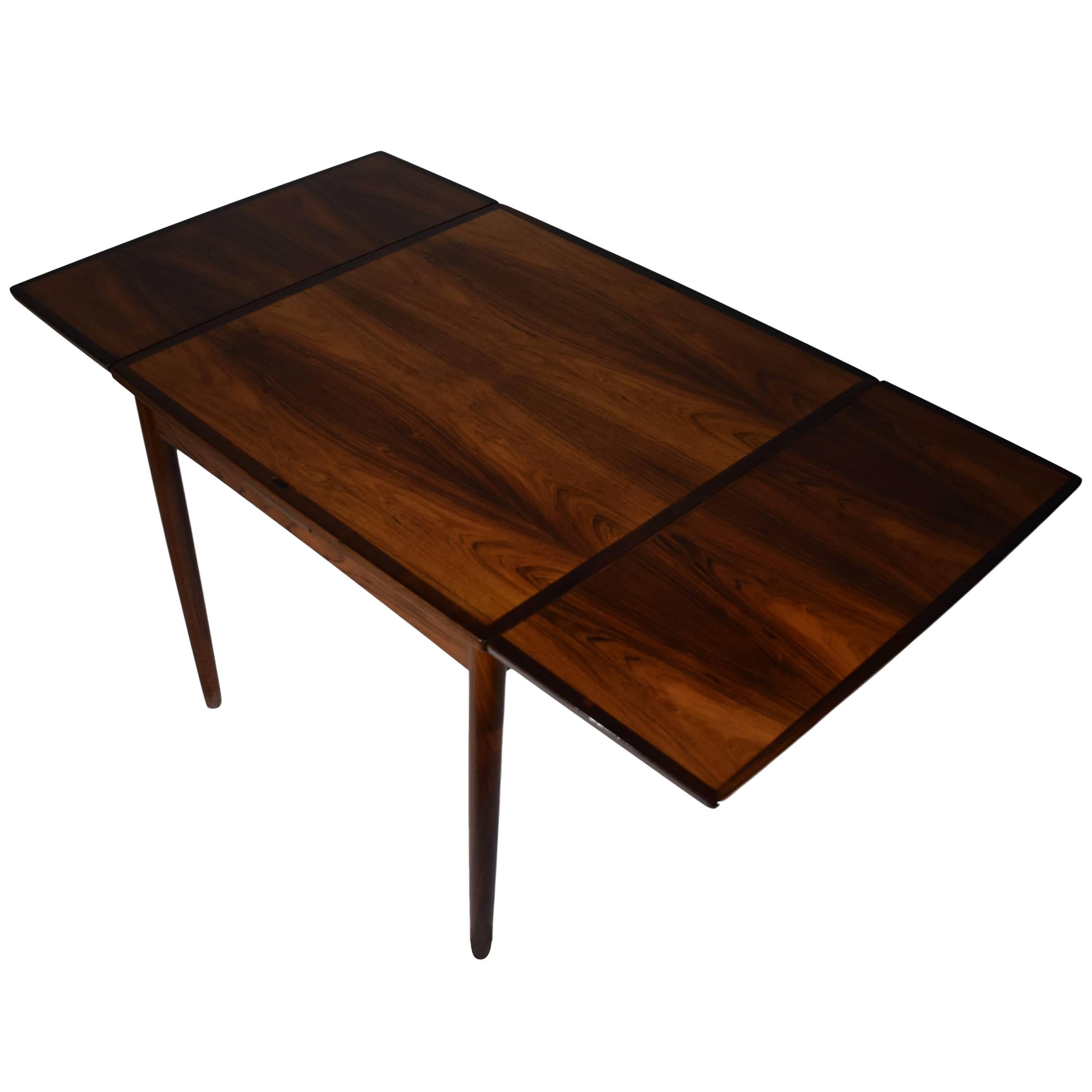 A Danish midcentury games table / dining table by Poul Hundevad (1917-2011). Reversible tabletop covered with black leather on the backside. Two extension leaves. Rosewood veneer and tapered solid rosewood legs. 

Measure: W 80-140 cm.
 