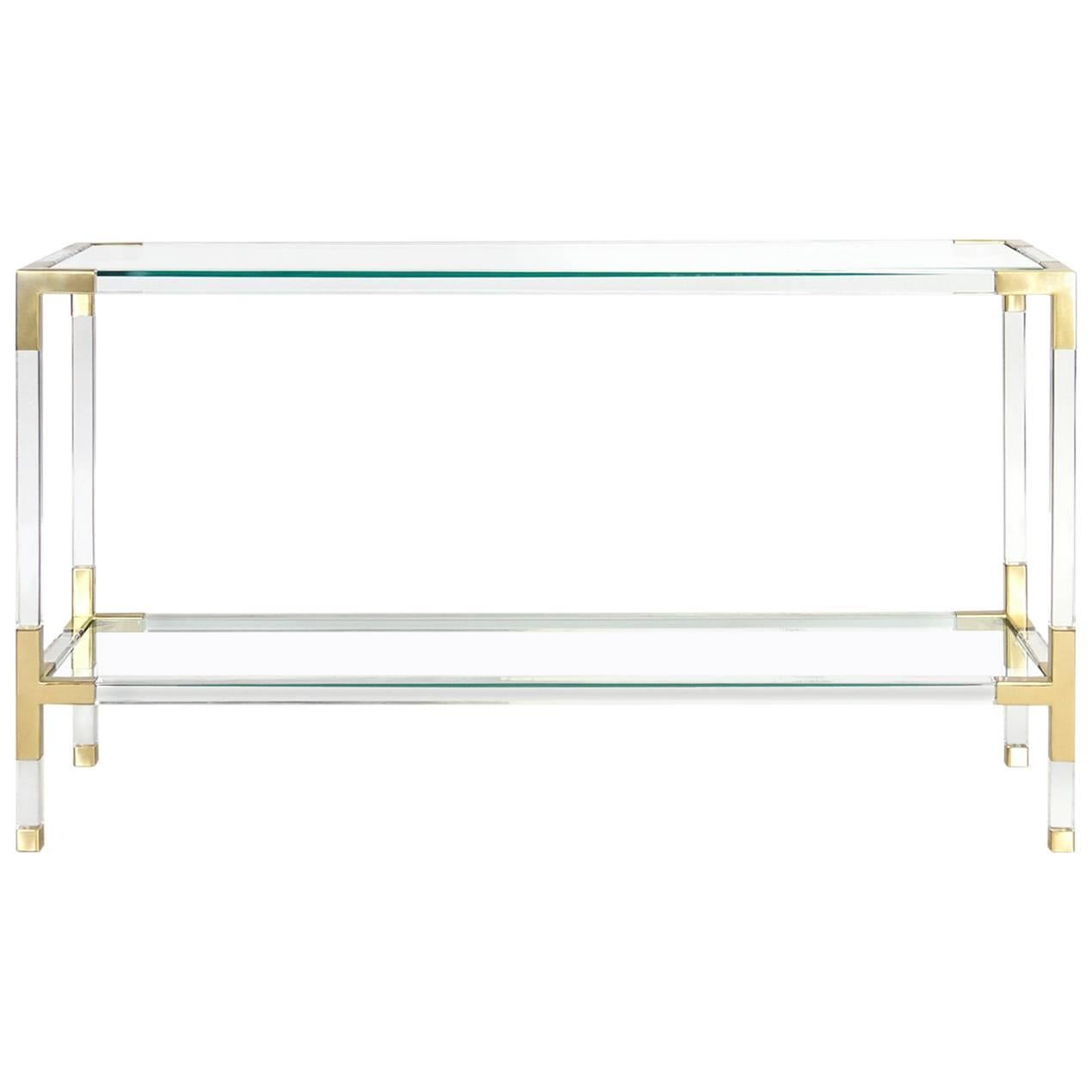 Clearly cool. Our Jacques collection is the perfect blend of simplicity and glamour, modern and traditional, in crystal clear Lucite with brushed brass corners. Fitted with a low glass shelf for baubles or books, our Jacques console works perfectly