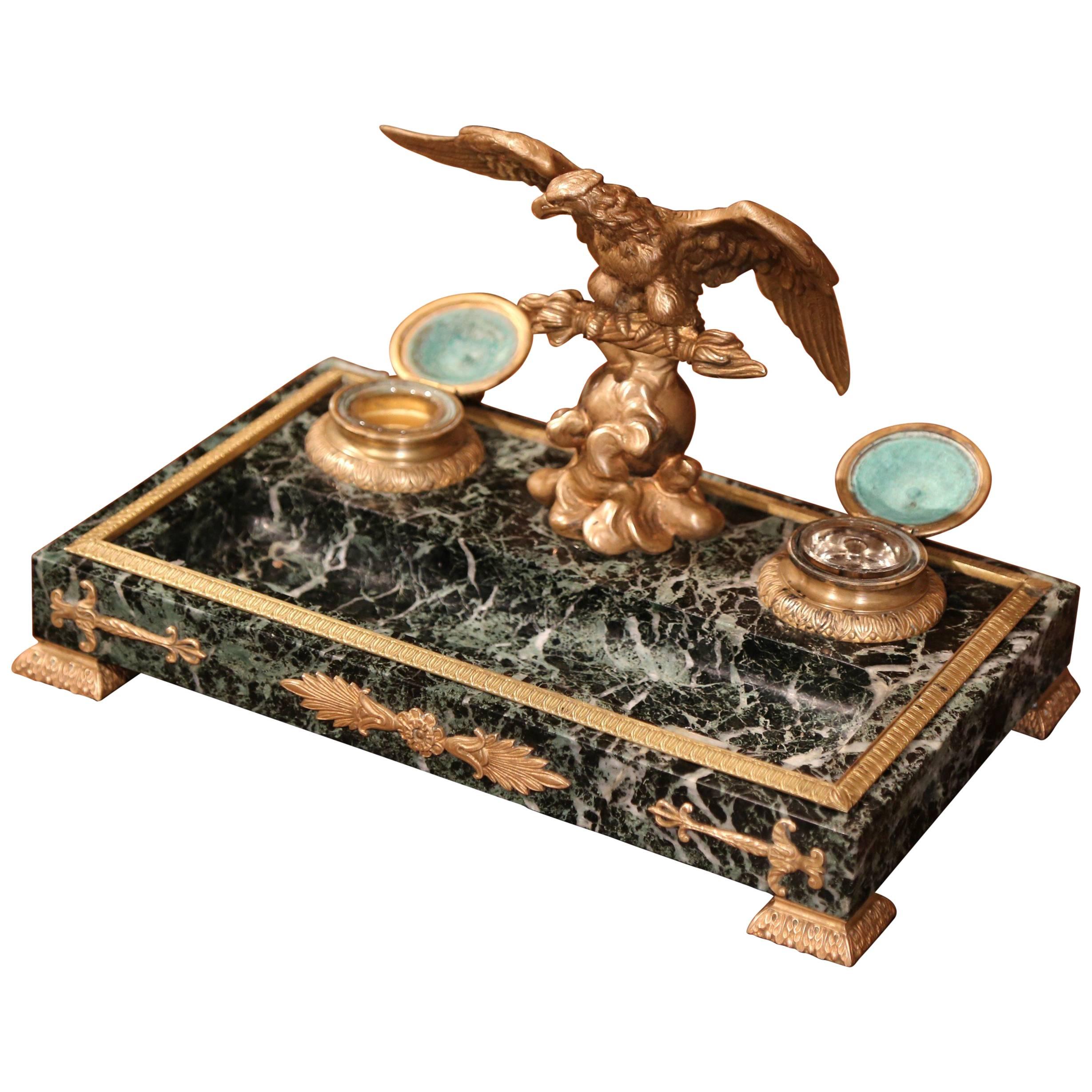 Decorate your desk or study with this elegant inkwell. Crafted in France, circa 1920, the antique desk accessory on dark green marble base features a bronze eagle standing on a tree branch, two round glass ink containers inside their bronze holders