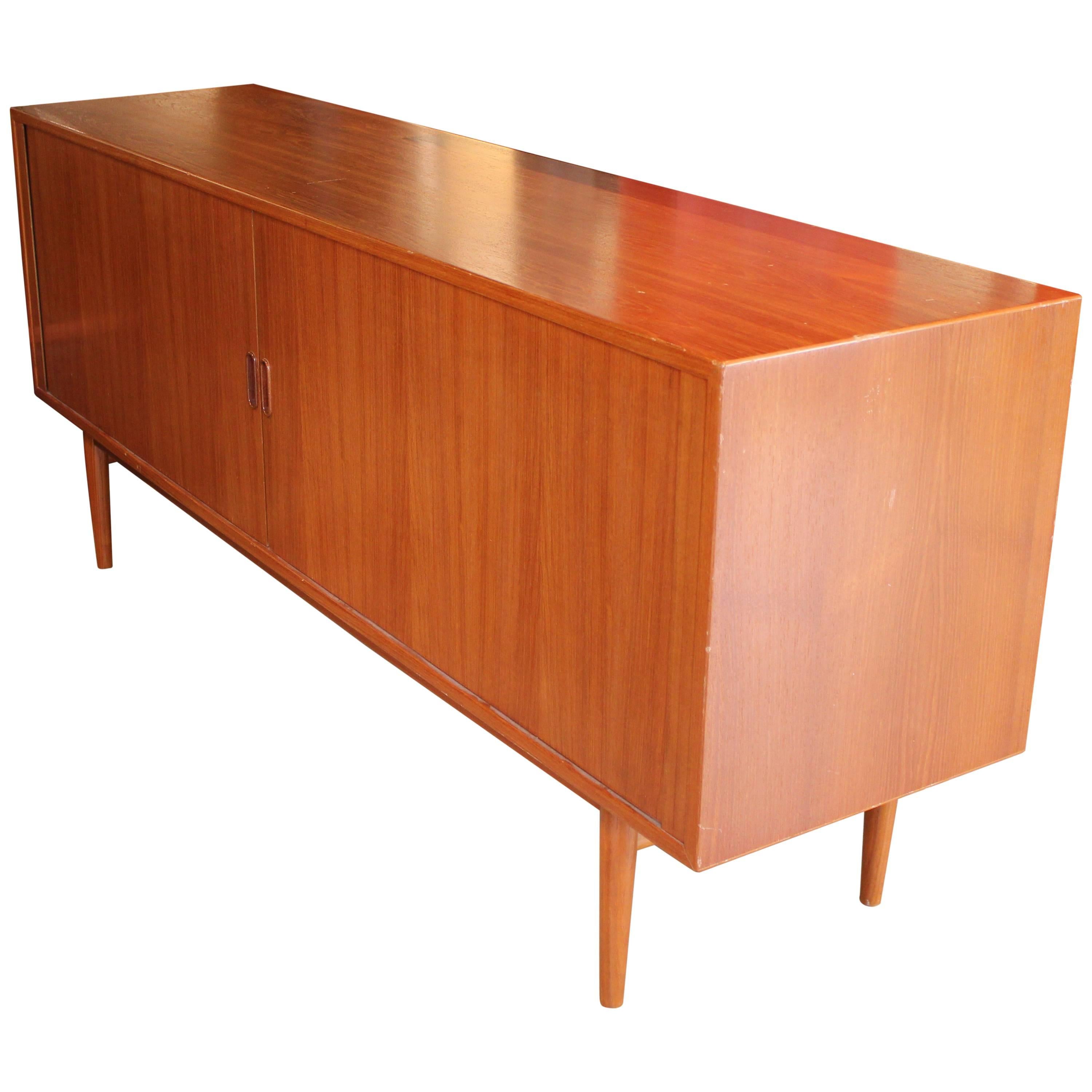 Gorgeous teak credenza or sideboard by Arne Vodder for Sibast Furniture with tambor doors.  The two doors open to reveal various shelving options and two drawers. Perfect for any modern or mid-modern space. 