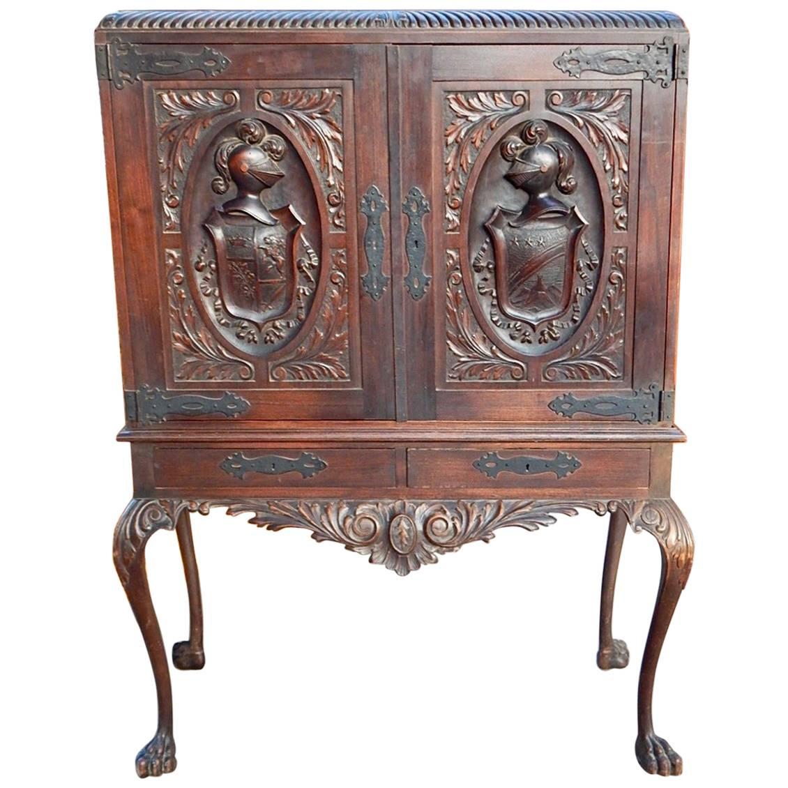 Argentine Spanish Colonial storage cabinet with heraldic theme doors and hand carved animal leg base. 
 With hammered metal strap hinges. In original condition as acquired in South America. Circa 1920
Item is sold without original key but is