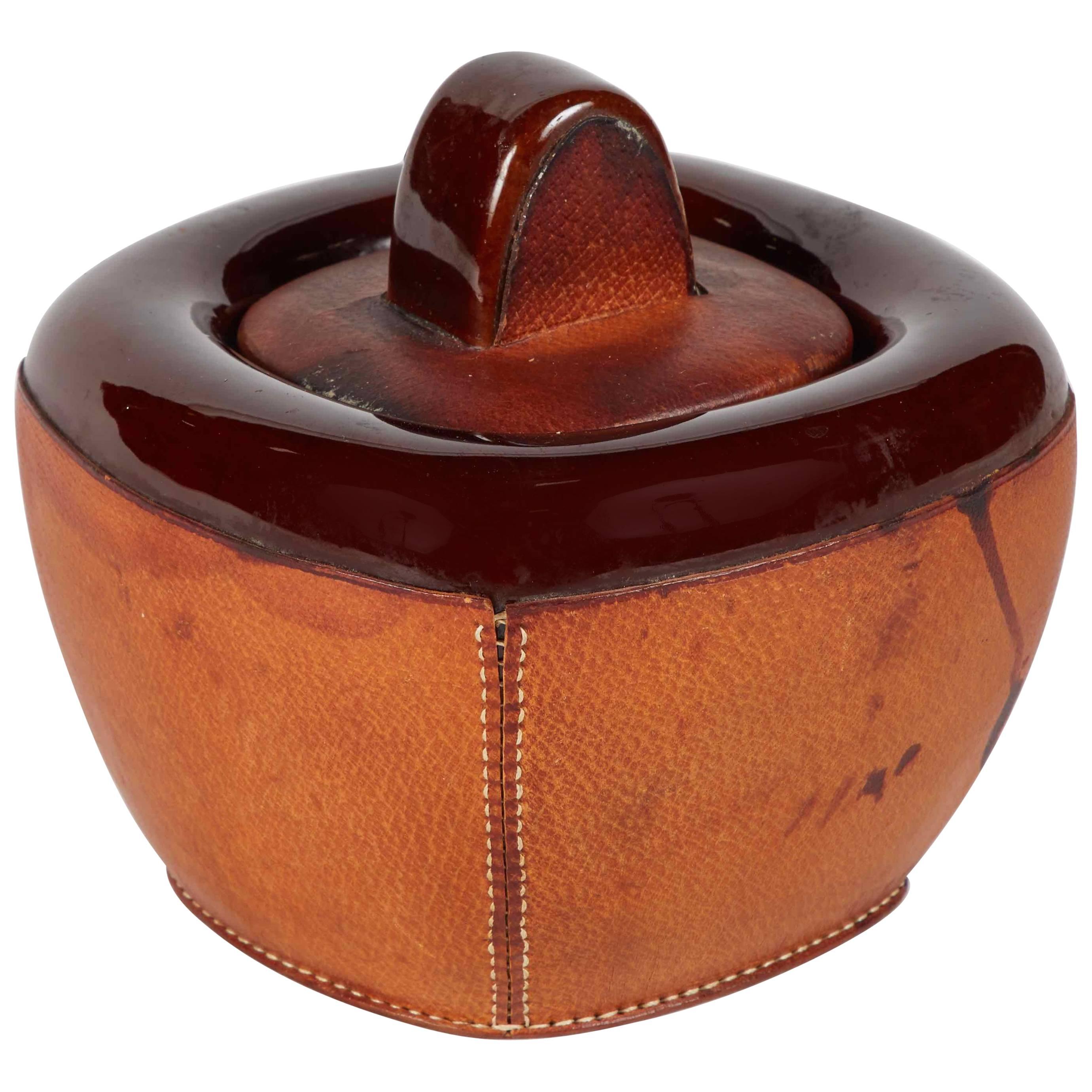 A Small Pottery Jar with Brown Leather Decoration and Lid