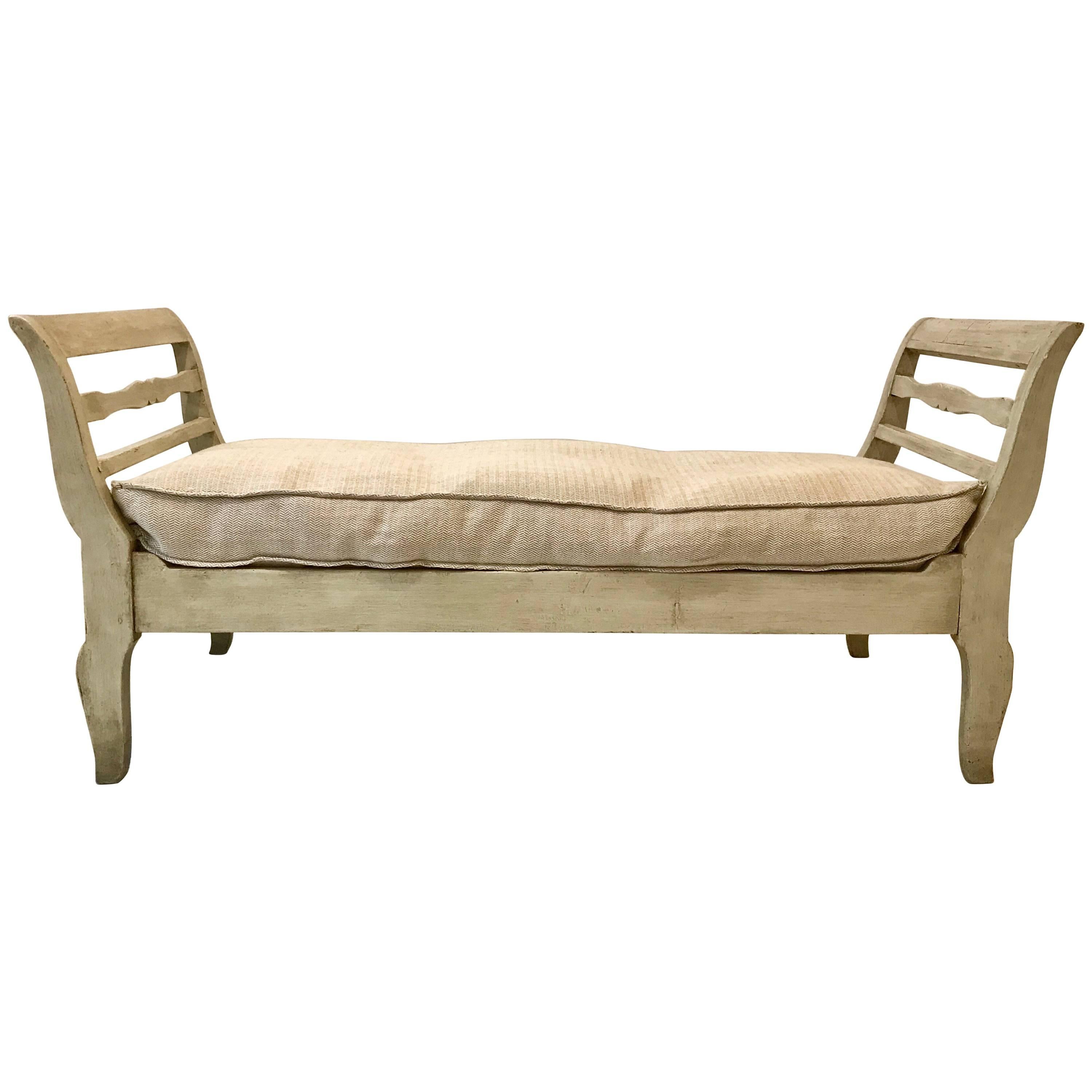 A fetching French provincial daybed having gracefully out swept arms and an older attractive dove grey paint finish. The frame shows very gentle wear throughout and is tight and ready for everyday use in any fine interior. The daybed sells and ships
