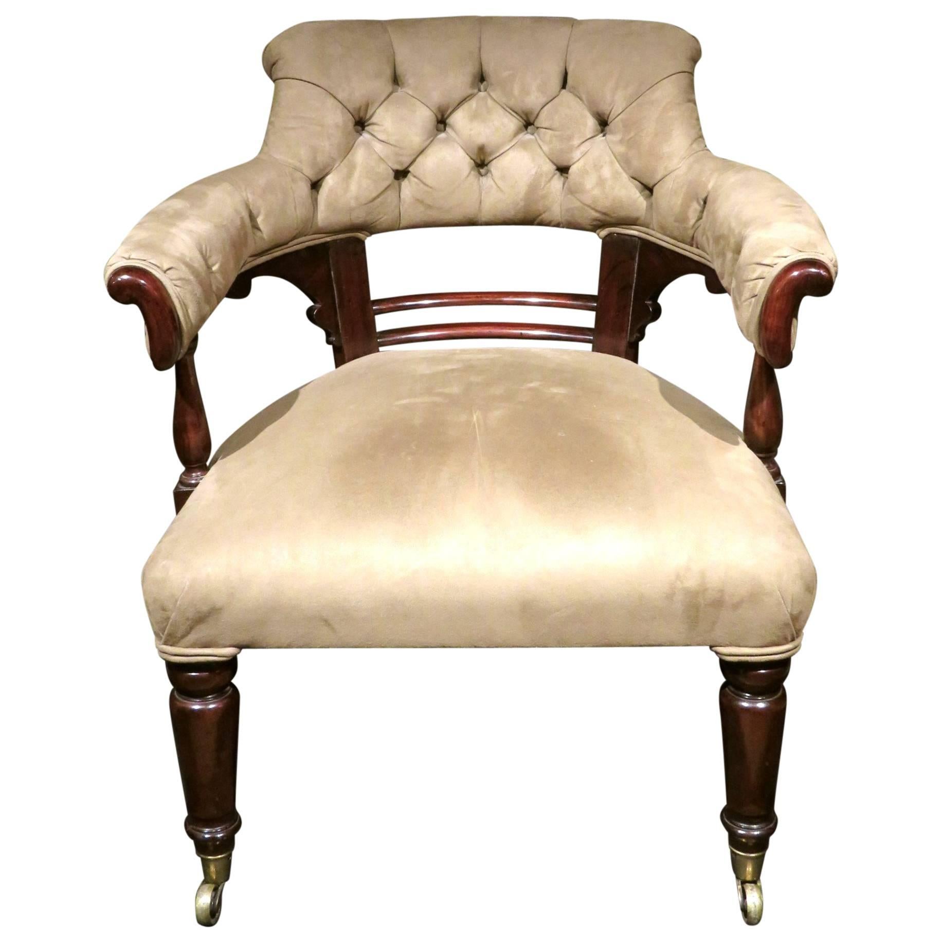 The mahogany frame showing a button tufted backrest and open armrests above a sprung seat, raised on turned front supports and splayed rear supports fitted with brass castors.
(Dear Client, please note we are in the process of finding a means to