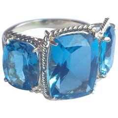 Bague  trois pierres avec topaze bleue et bordure en forme de corde torsade