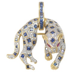 Spilla/pendente con pantera in zaffiro blu, diamante e rubino, con montatura in oro 18K