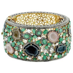 Bracelet manchette de style ornemental serti d'émeraudes, de saphirs géométriques et de diamants pavés