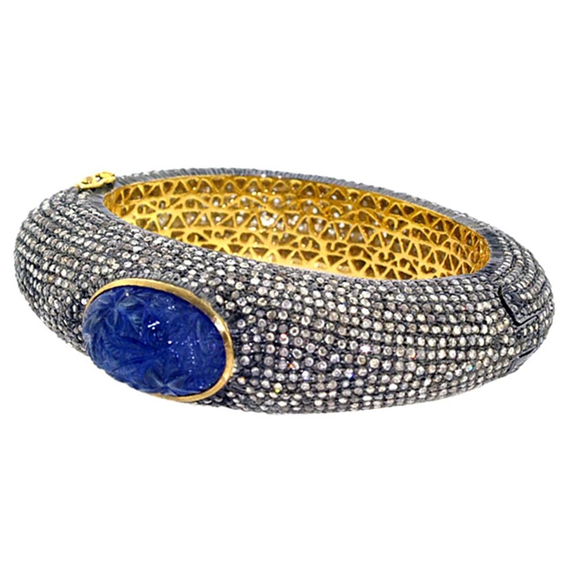 Graduating Pave Diamond Bangle With Carved Tanzanite In Center For Sale