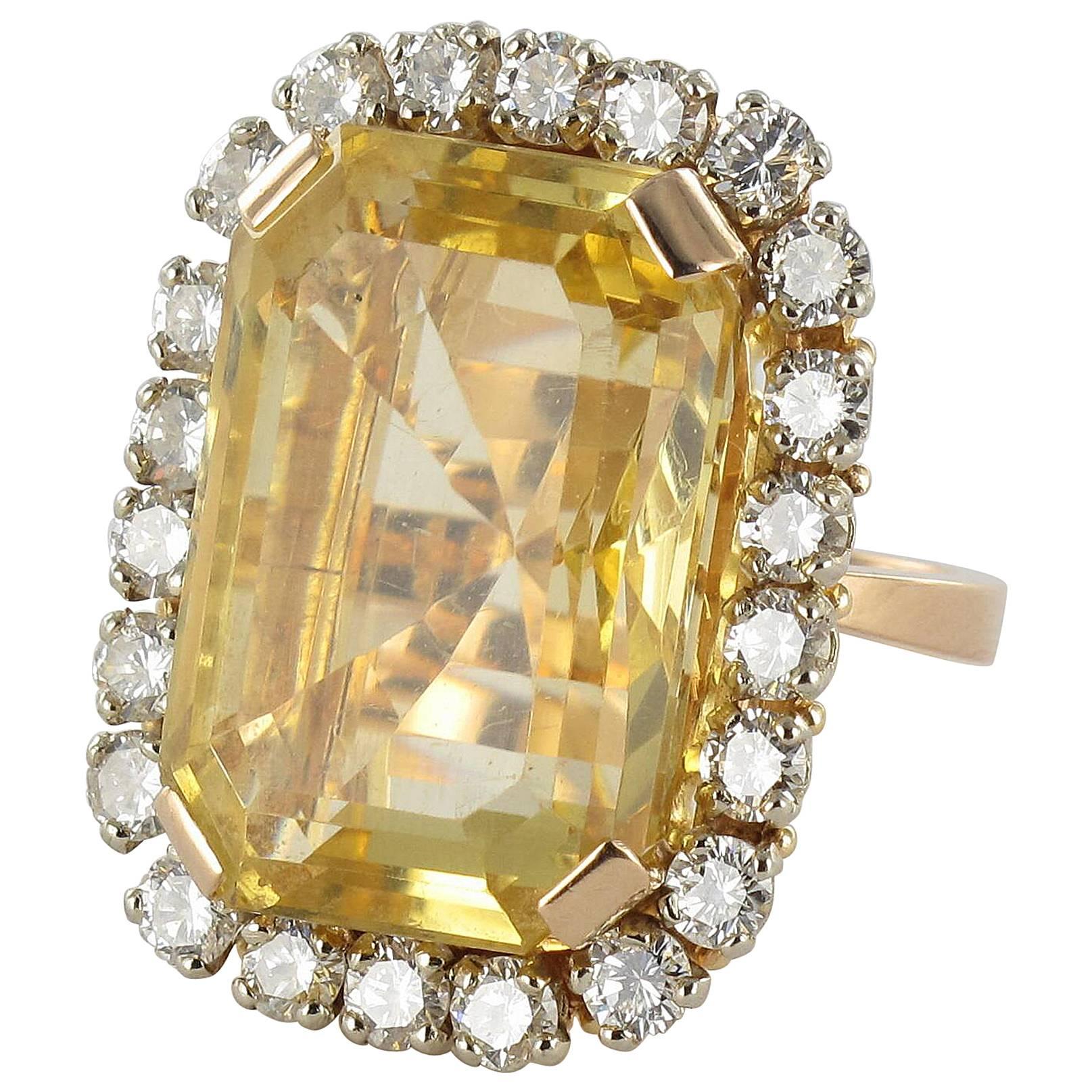 Yellow gold ring, 18 Karat.
This splendid large gold ring boasts a magnificent claw set emerald cut citrine surrounded by brilliant cut diamonds. 
Weight of Citrine: approximately 22.85 carats.
Total weight of diamonds: 2.65 carats