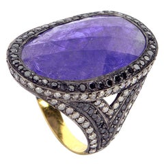 Anello con fetta di tanzanite circondata da diamanti bianchi e neri