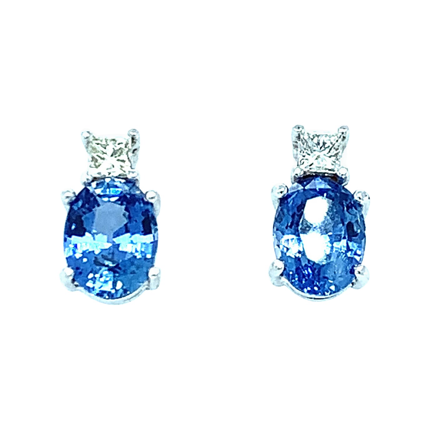 These sparkling earrings feature 2 oval blue sapphires that have a combined weight of 3.40 carats. These blue sapphires have crisp, clear color like a perfect summer day! Two princess cut diamonds sit on the ear lobe and add that extra touch of