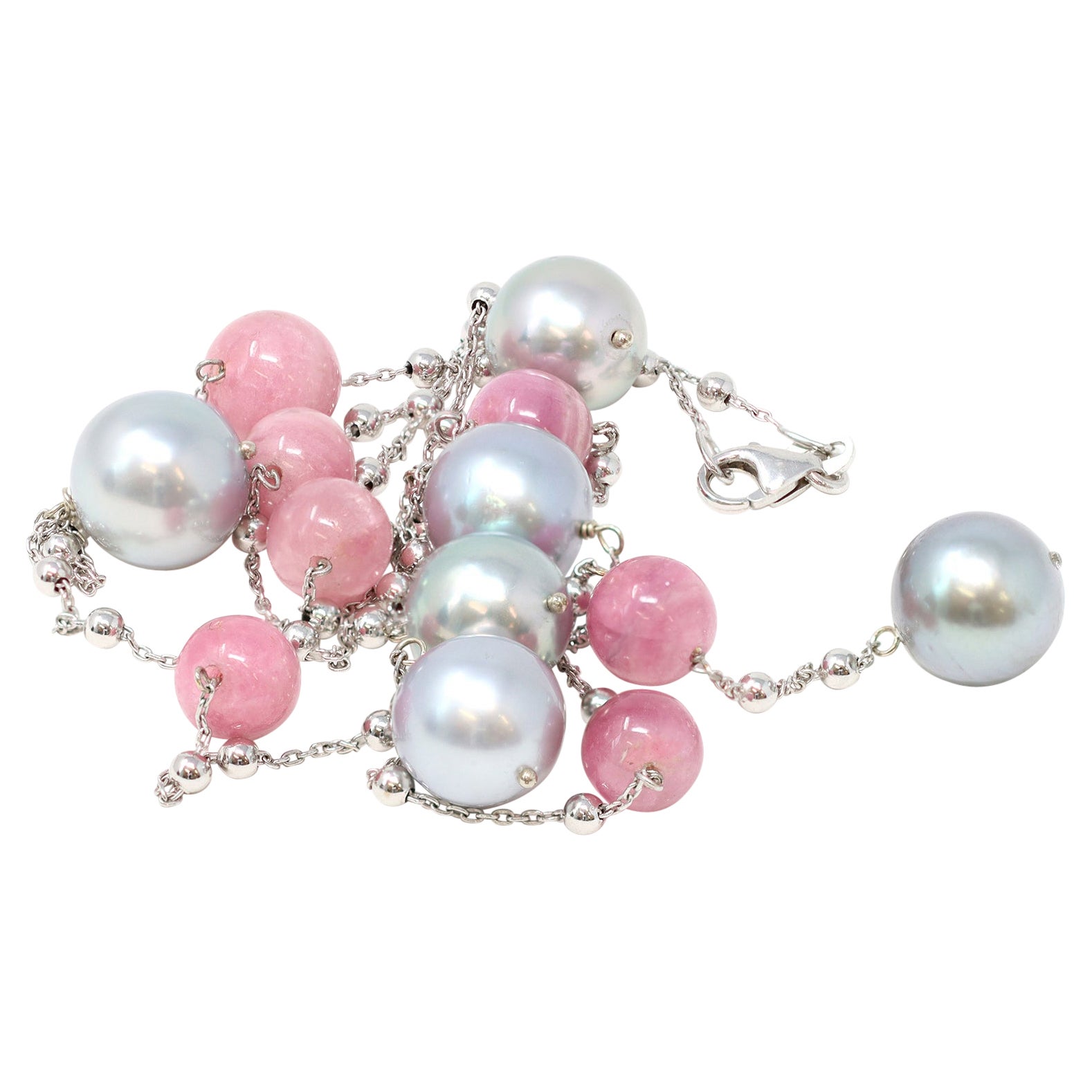 A dainty yet striking necklace by Rosaria Varra, featuring matched light silver Tahitian pearl round shape, and natural light pink tourmaline beads mounted as a station style necklace. The piece is set in 18 karat white gold with tiny gold beads and