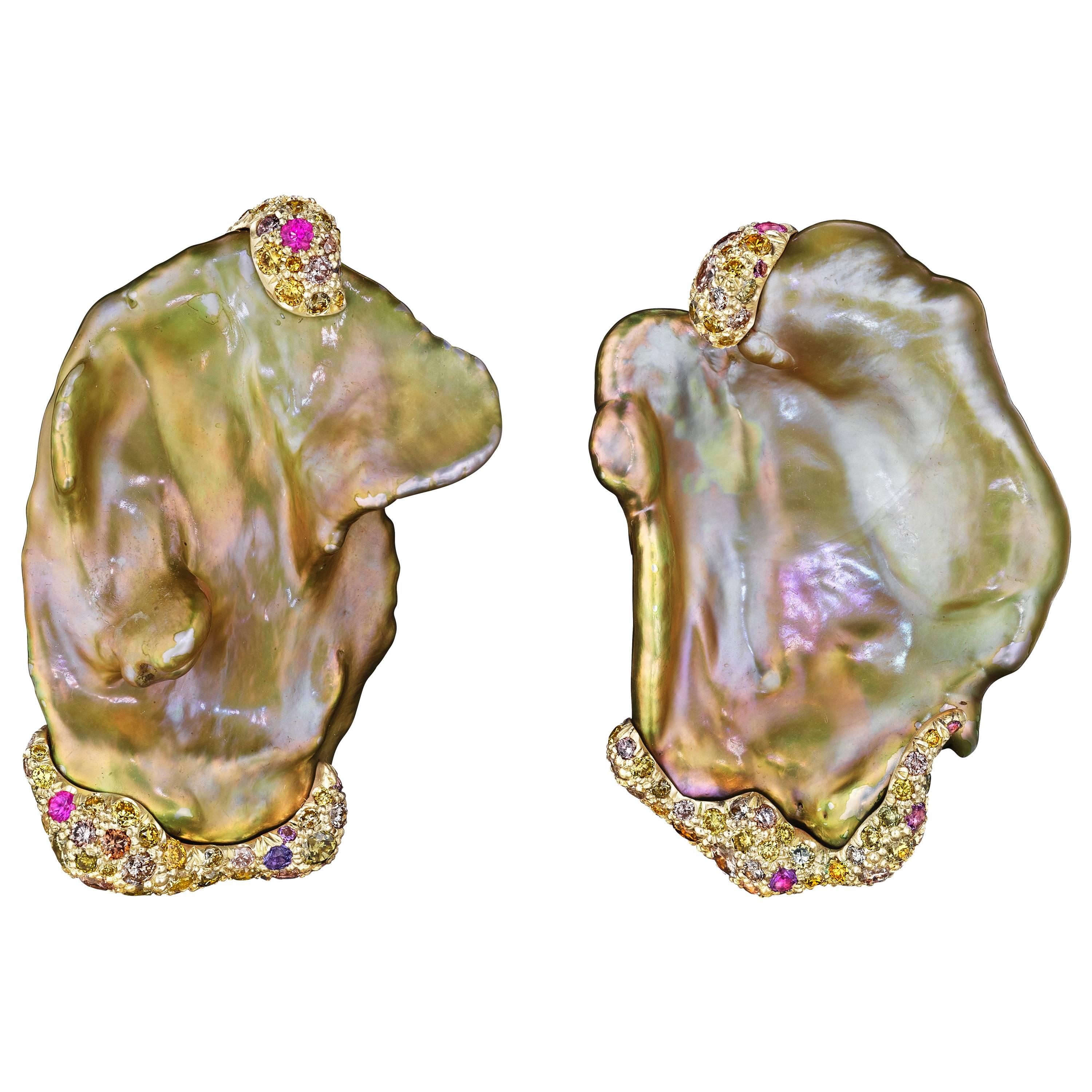 These eye-catching earrings feature a pair of Chinese freshwater pearls accentuated by multicolored diamonds and sapphires set in 18K yellow gold.

Internationally award winning designer Naomi Sarna creates gem carvings and jewels of unusual beauty.