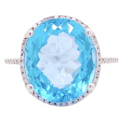 Anillo halo de topacio azul y diamantes, topacio azul ovalado, oro blanco y garras de diamantes
