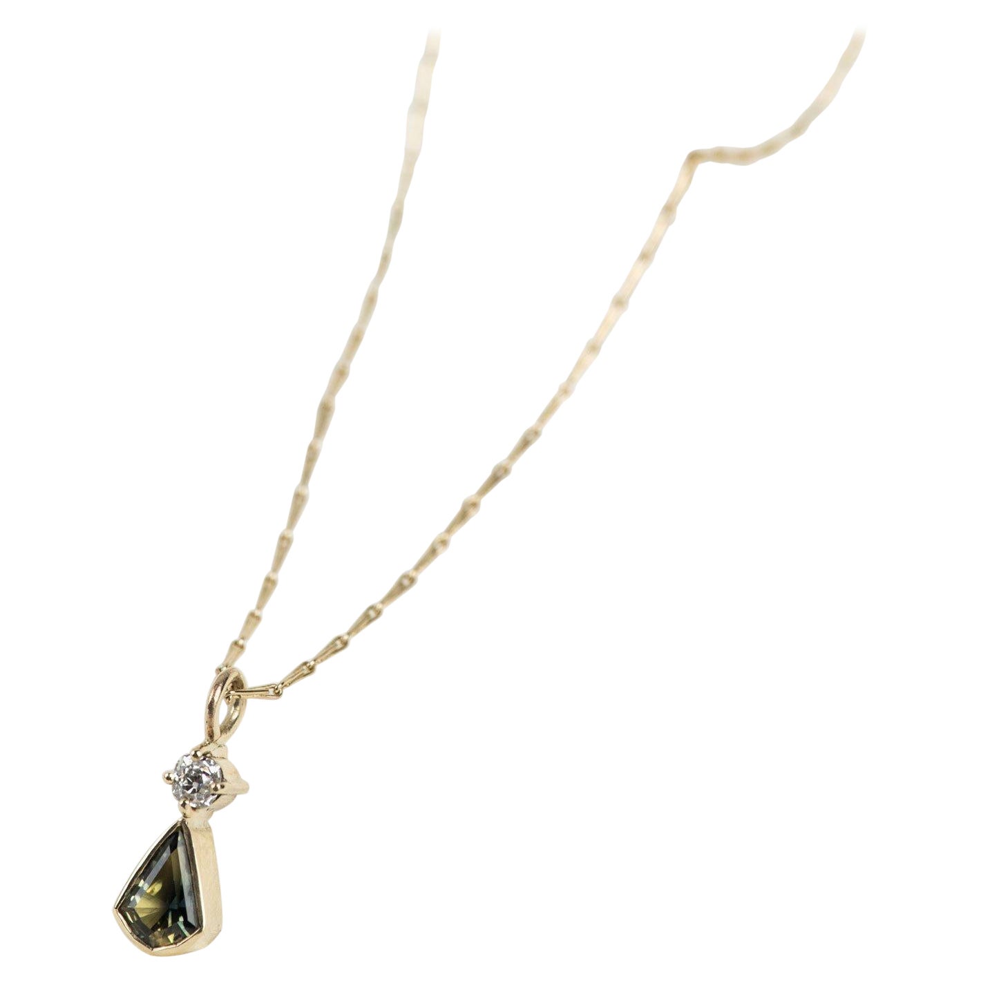 This beautiful 18inch yellow gold hayseed chain holds a glistening unheated Australian parti-sapphire in a rub-over setting. Above the main stone, you can find shimmering reclaimed diamond delicately set in a claw setting. The perfect ethical