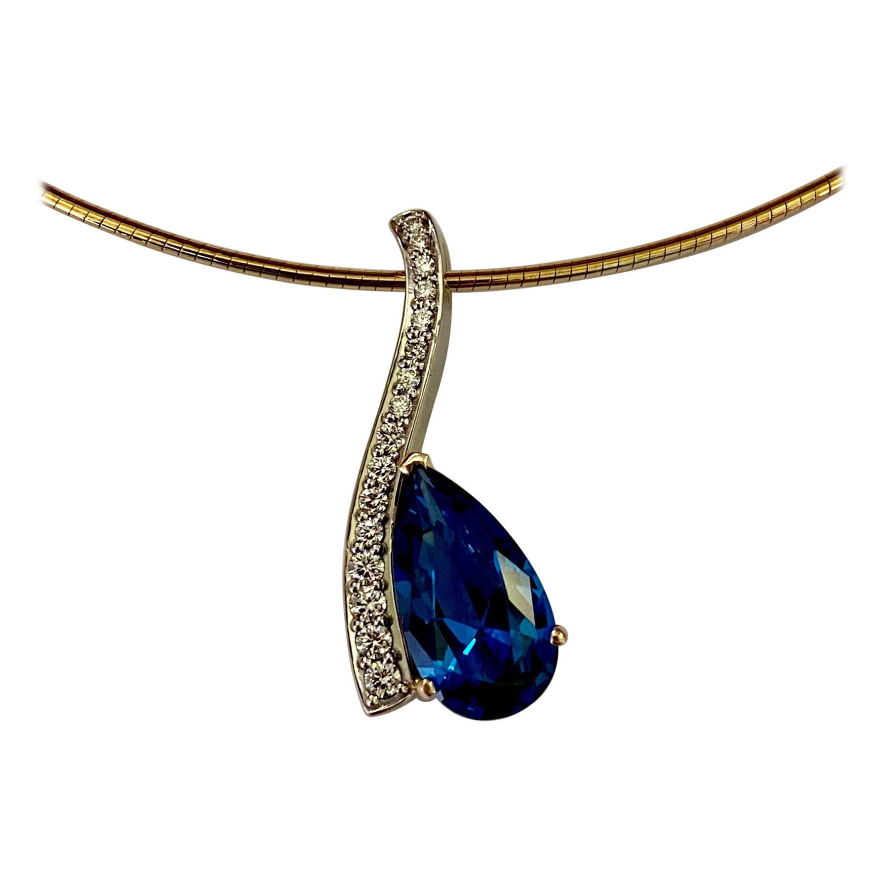 Blue topaz is showcased in this diamond Wavy pendant.  The topaz is an elegant pear shape that perfectly conforms to the curves of the diamond pave setting.  The gem is what might be described as cornflower blue in color and is exceptionally well