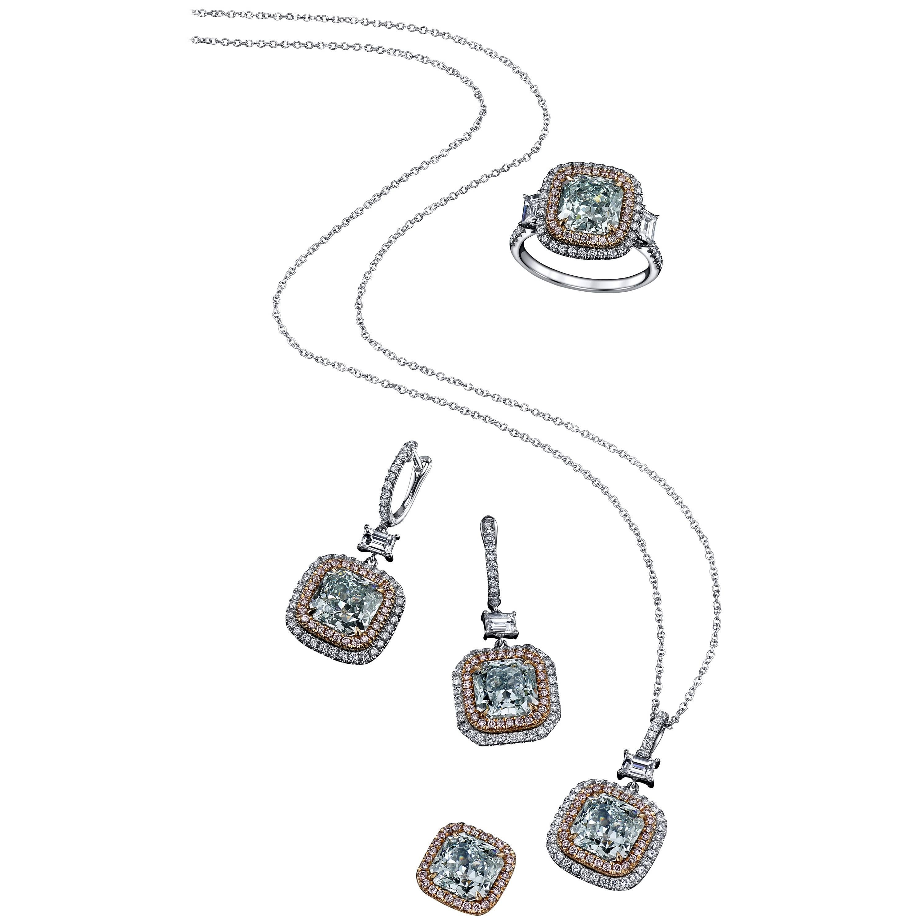 A one-of-a-kind interchangeable natural fancy color diamond set, sold as a pair of earrings, with the ring and pendant mounting included.
The two center stones are surrounded by a natural pink diamond halo, which has a back-clasp which easily