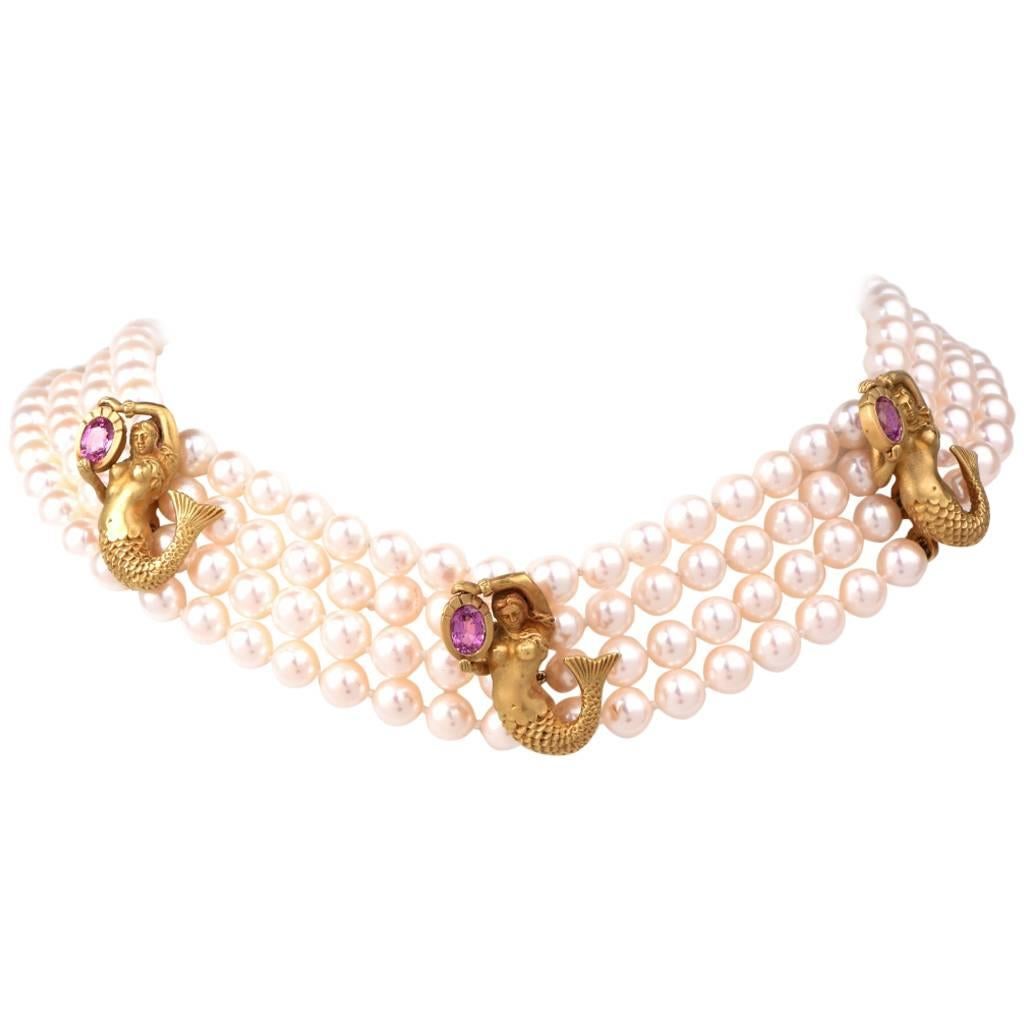 This impressive designer Barry Kieselstein necklace ** comprises 4 strands of lustrous silk-strung cultured pearls of an enchanting 'pinkish white' color, measuring 7mm in diameter. The pearl strands are intersected by 5 yellow gold cylindrical