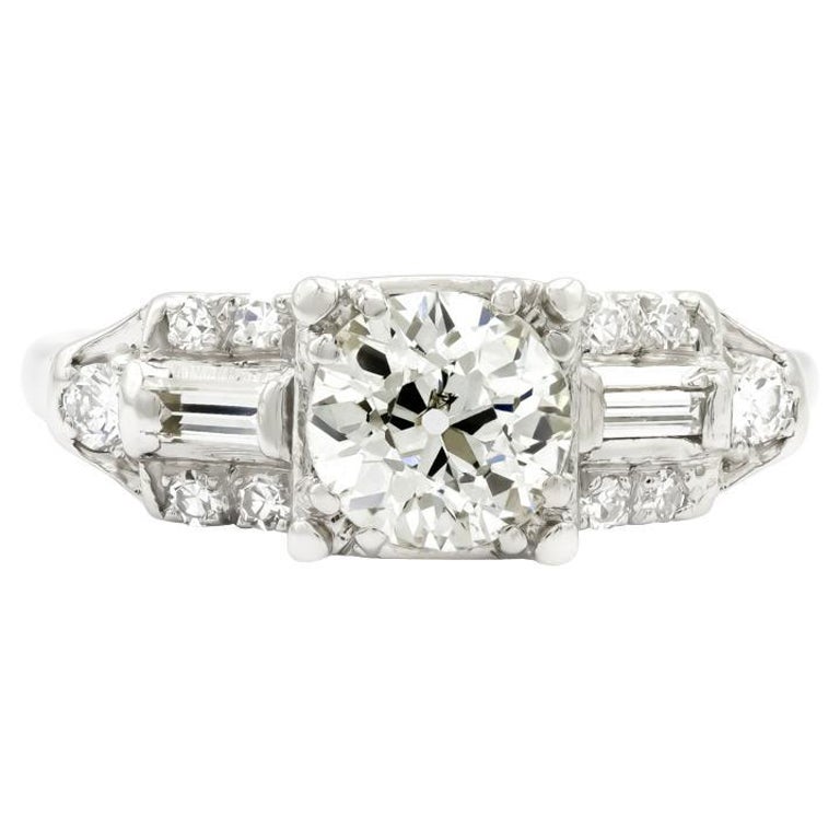 A ring to make your heart sing, with all the makings of art deco era magic. This engagement ring holds the most radiant old European cut, just under 1 carat and scintillating at every angle. We absolutely love the straight baguette accented