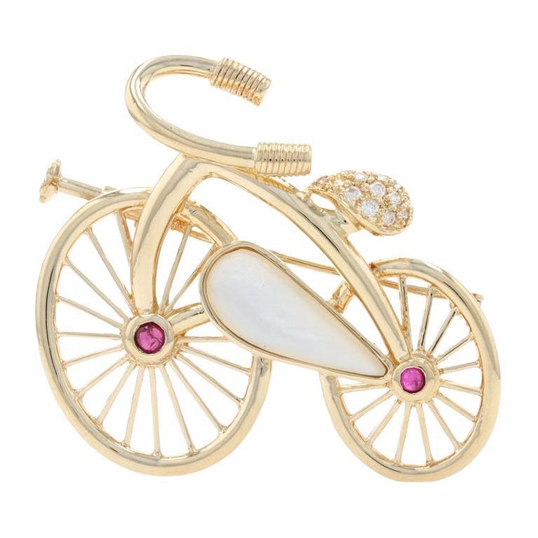 Broche bicyclette en or jaune 18 carats avec nacre, rubis et diamants, poids total de 0,28 carat