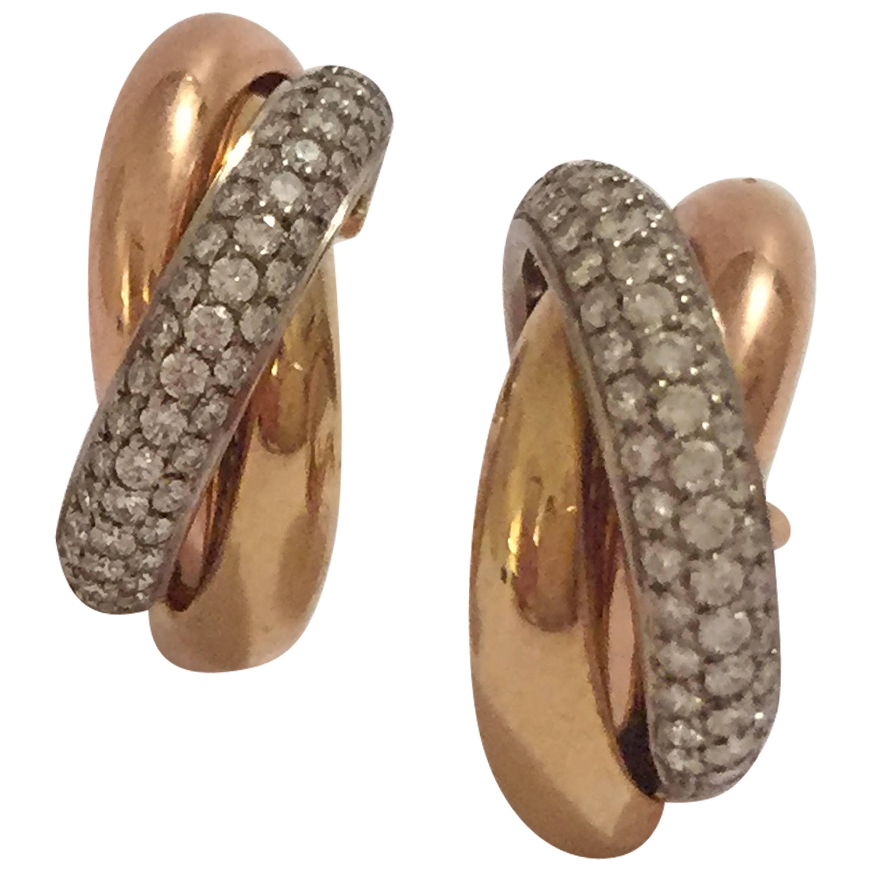 18kt Cartier De Trinity Three Row Hoop Earring with Diamonds.  Yellow white and rose gold hoops complemented with a a diamonds row of approximately 70 diamonds weighing approximately 0.50 carats.

The earrings are pierced and finished with an