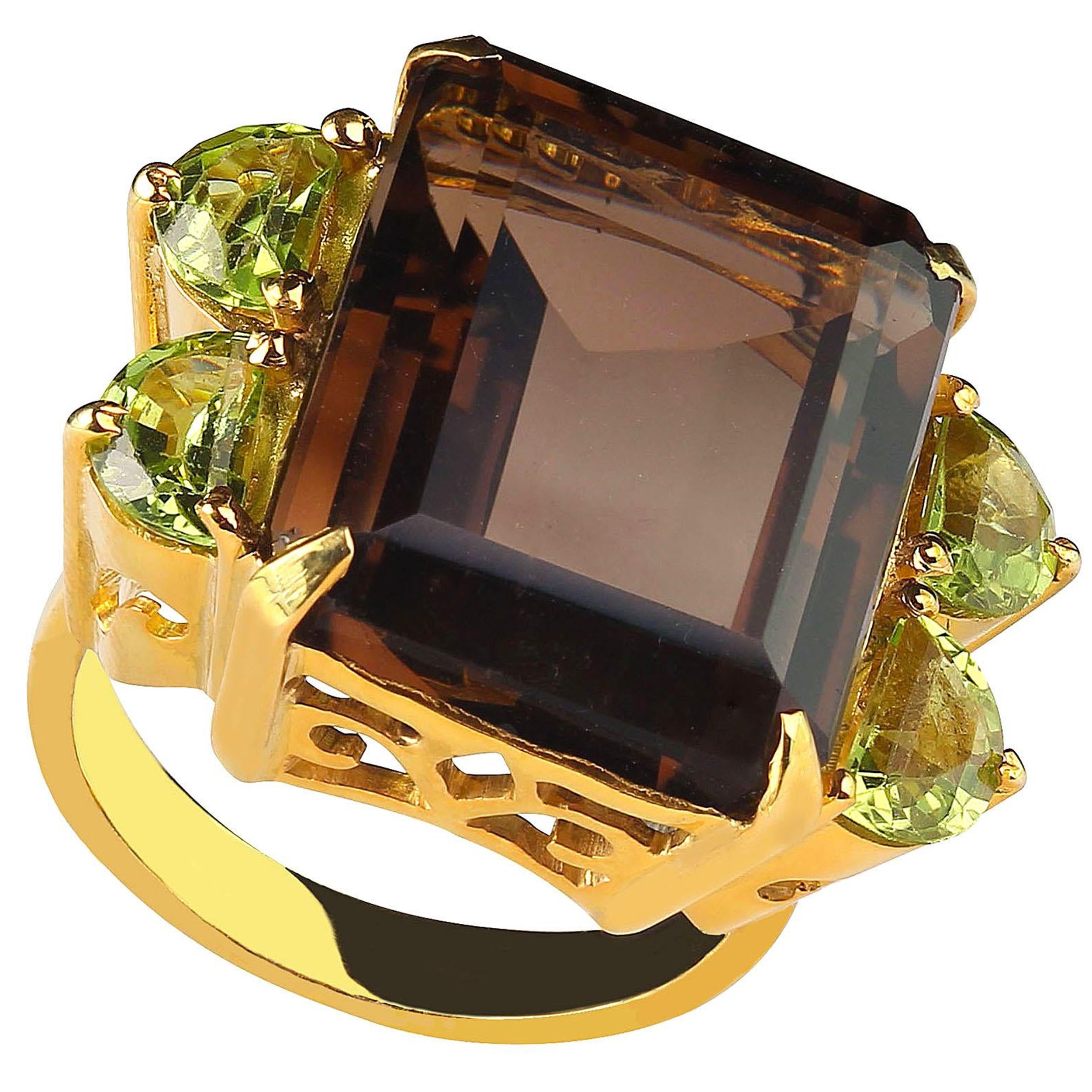 Bold dinner ring of Smoky Quartz and sparkling Peridot.  This sizable 7 ring loves to go out for cocktails and sparkles at dinner.  The emerald cut Smoky Quartz is 18.86 carats and the adorable side Peridot have a total weight of 2.03 carats.  They
