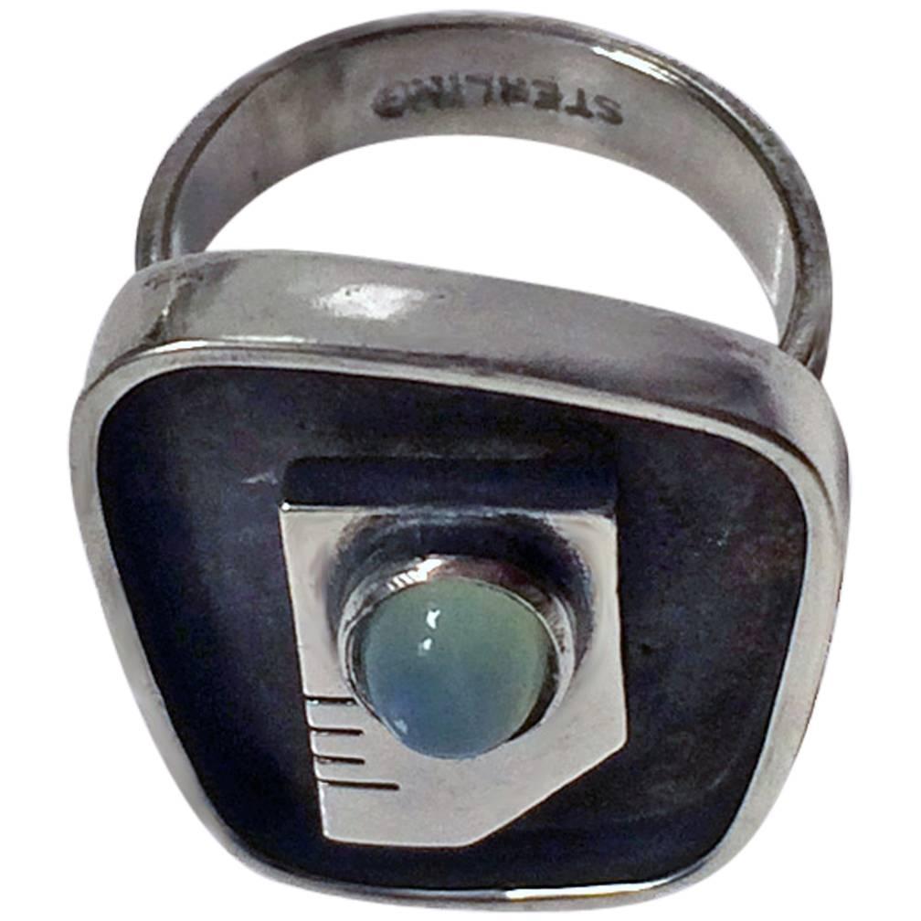 Ed Wiener Sterling Silver abstract modernist face Ring with chalcedony cabochon eye, Ed Wiener, New York, C.1950. Size 7. Signed Ed. Wiener, Sterling on reverse. Total Item Weight: 10.23 grams.