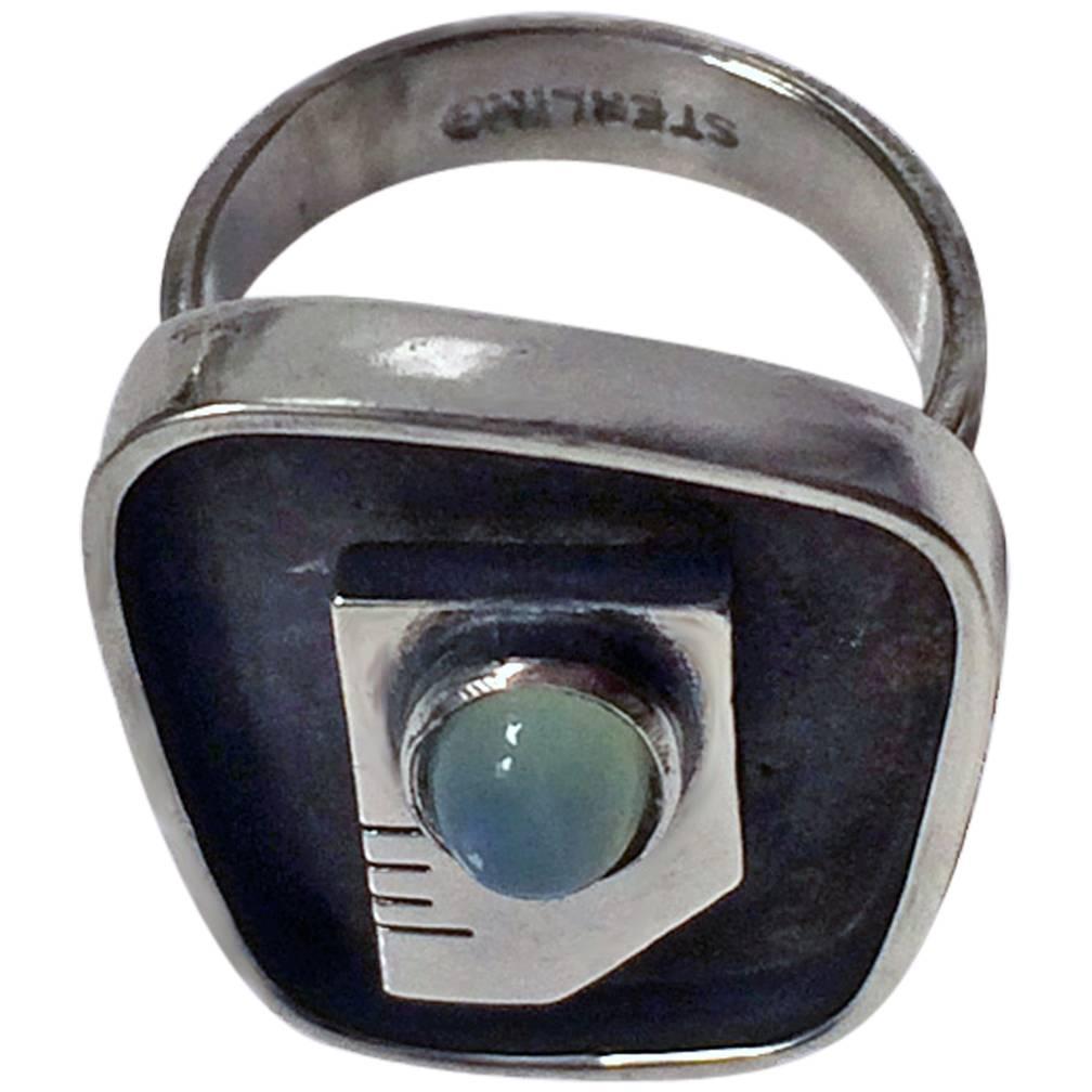 Ed Wiener Anello astratto modernista in argento sterling con occhio cabochon in calcedonio, Ed Wiener, New York, C.1950. Formato 7. Firmato Ed. Wiener, Sterling sul retro. Peso totale dell'articolo: 10.23 grammi.