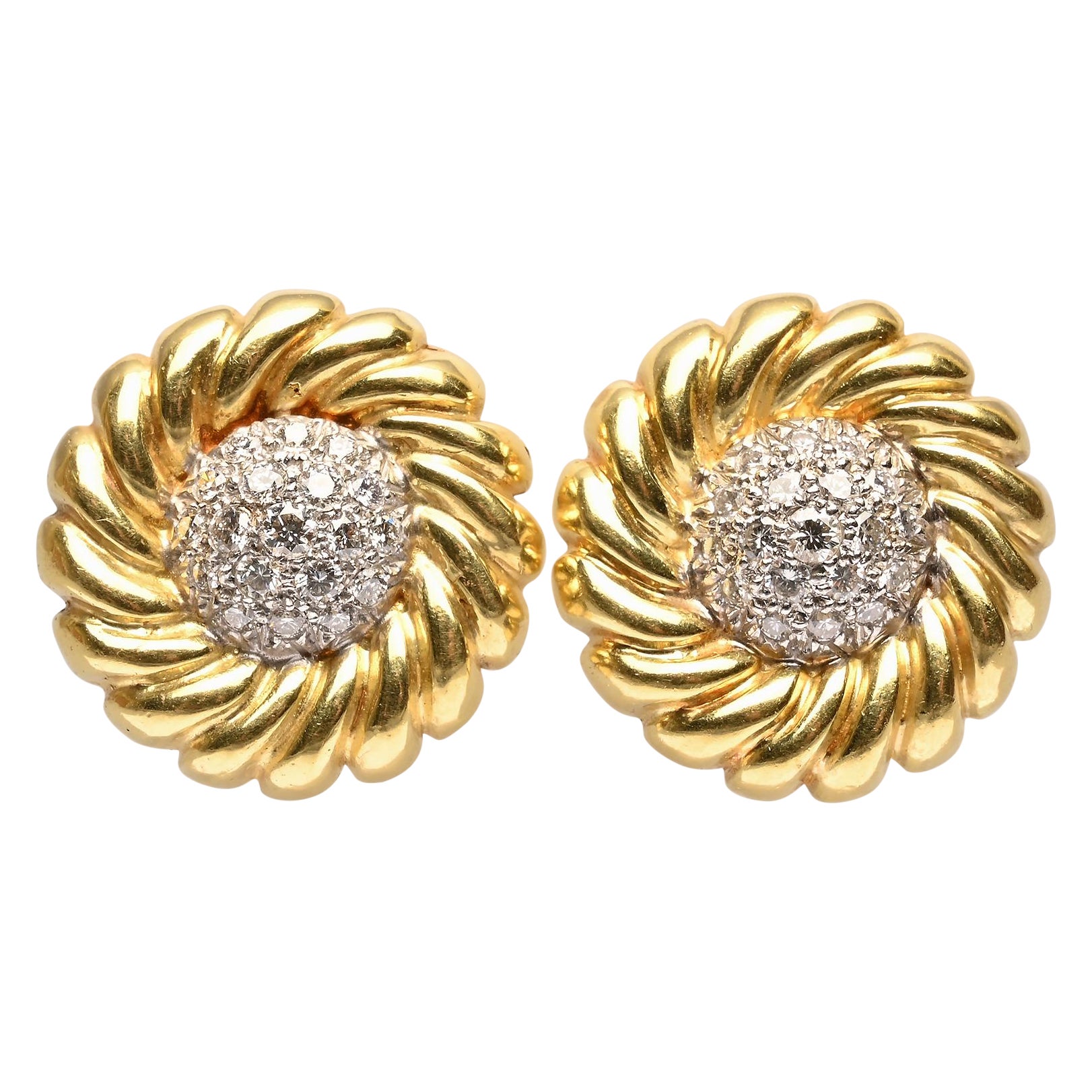 Stylish 18 karat gold earrings with a ribbed spiral encircling a center of diamonds. There are 38 diamonds weighing a total of 1 1/2 carats in a domed setting.
Clip backs can be converted to posts.
