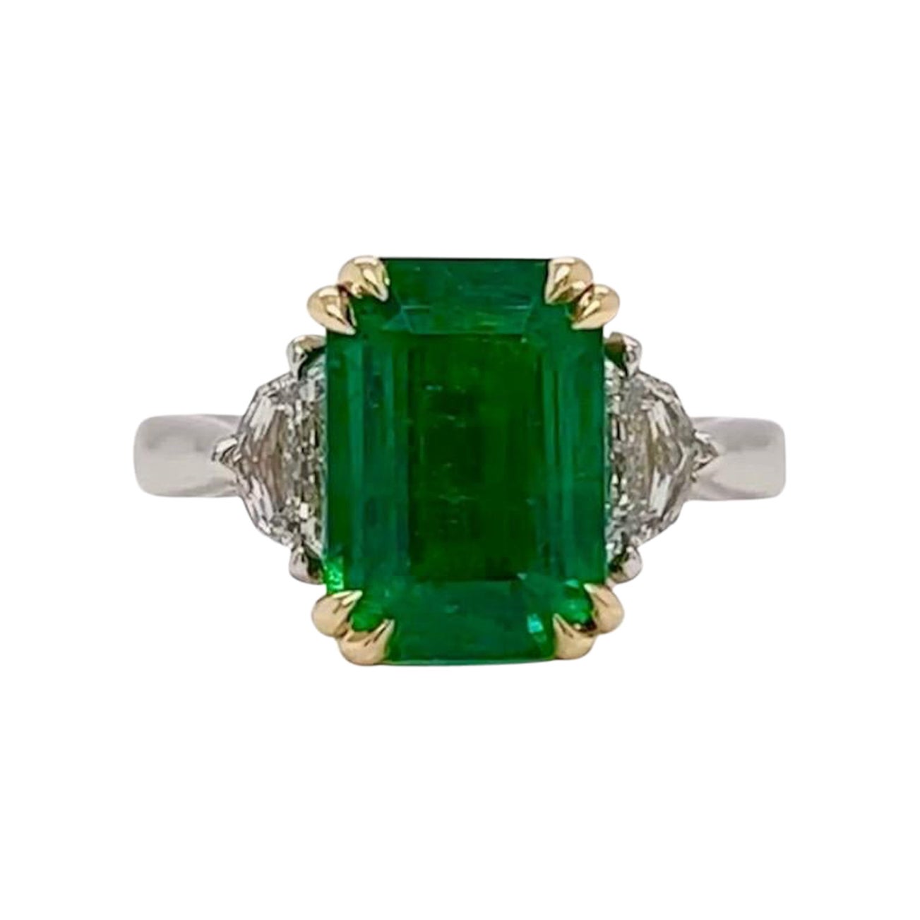 4.29ct gorgeous fine vivid green Emerald with an elegant elongated proportion & 0.53ctw F/G VS Epaulette shaped side stones. 

Set in an expertly crafted Platinum & 18K Yellow Comfort fit setting. 

Ring Size 6.5