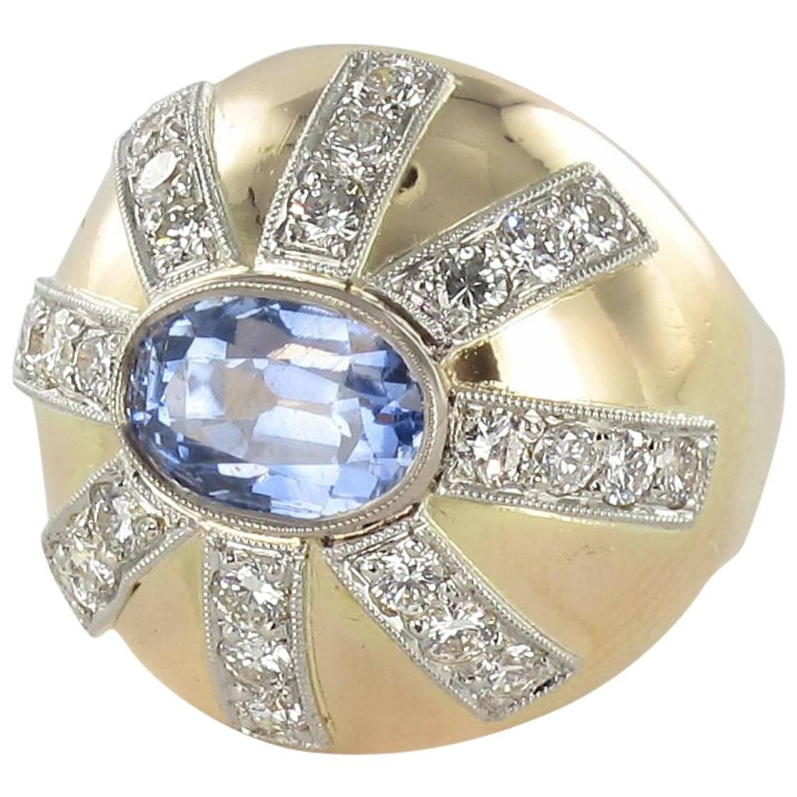 Ring in 18 carat yellow gold and platinium, owl hallmark. 

This splendid ring is composed of a golden dome which is set with an oval sapphire with a milgrain border. This is surrounded by an 8 branch star motif, each branch featuring 3 brilliant