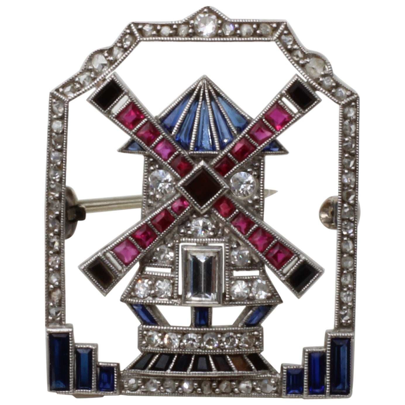 A 0.85 Carat Platinum Art Deco Windmill Diamond, Ruby, Onyx & Sapphire Brooch