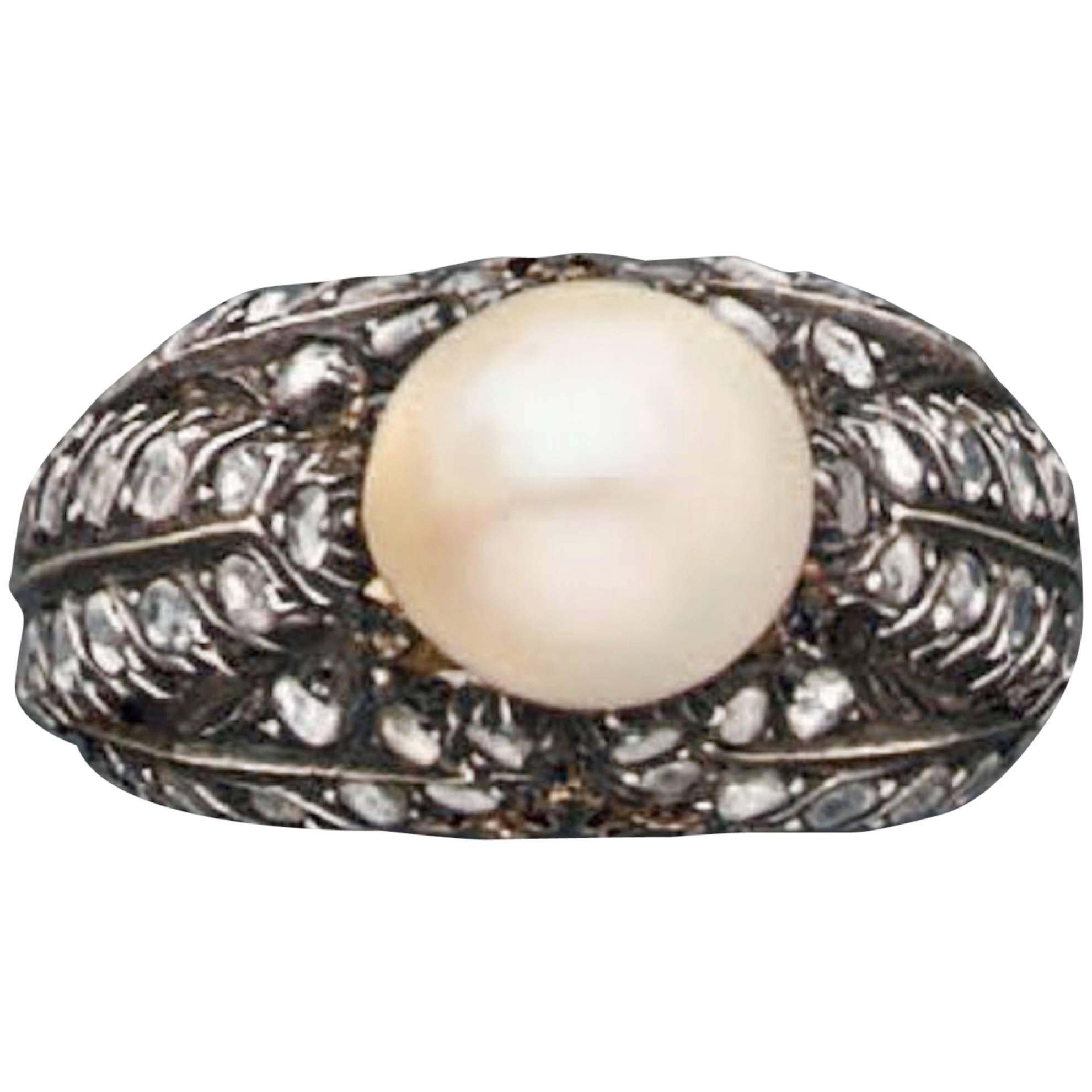 A cultured pearl (9.1-9.7 mm) and rose cut diamond mounted in yellow gold 750 and silver 800. The ring is all engraved.
Signed Mario Buccellati.
Circa 1920
Gross weight: 10 grams.
Size: 6 (US) / 52 (EU)