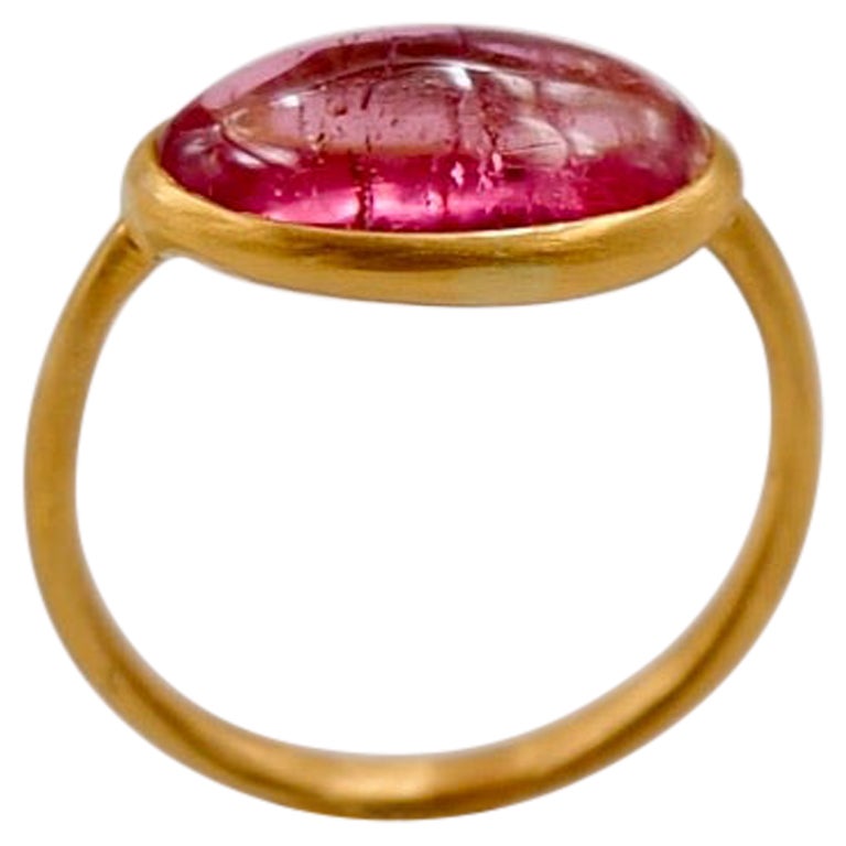 This simple ring by Scrives is composed of pink tourmaline cabochon of 3.83 cts.
The stone is set in a 22kt closed gold setting.
This stone is natural and has natural & typical inclusions (eye-visible). 

This ring is handmade with 22kt mat finish