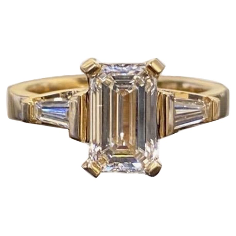 DeKara Design Collection

Métal - or jaune 18 carats, or blanc 18 carats, .750.

Pierres- Diamant central certifié GIA de taille émeraude de couleur J VS1 et de clarté 1,62 carats, deux diamants baguette de couleur H-I VS1-VS2 et de clarté 0,40