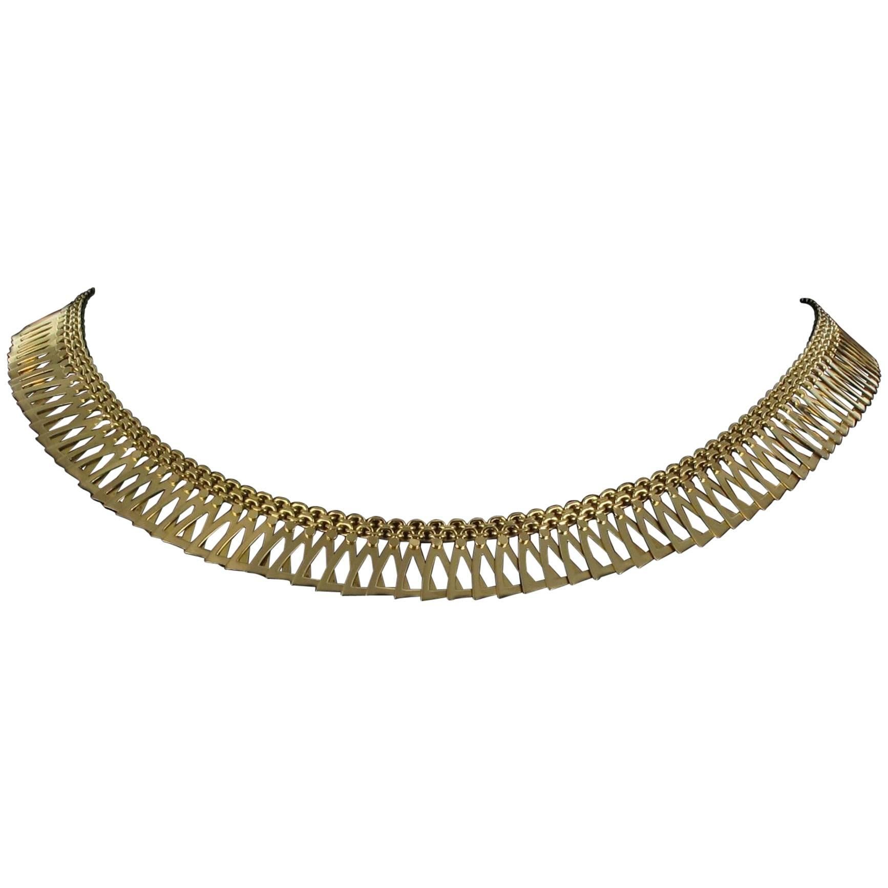 18 carat yellow gold necklace, eagle head hallmark.
A supple necklace formed of linked and overlapping triangular motifs joined at the top by a double belcher chain. This necklace has an 8 ratchet safety clasp.  
Height of grounds: 0.9 cm, width of