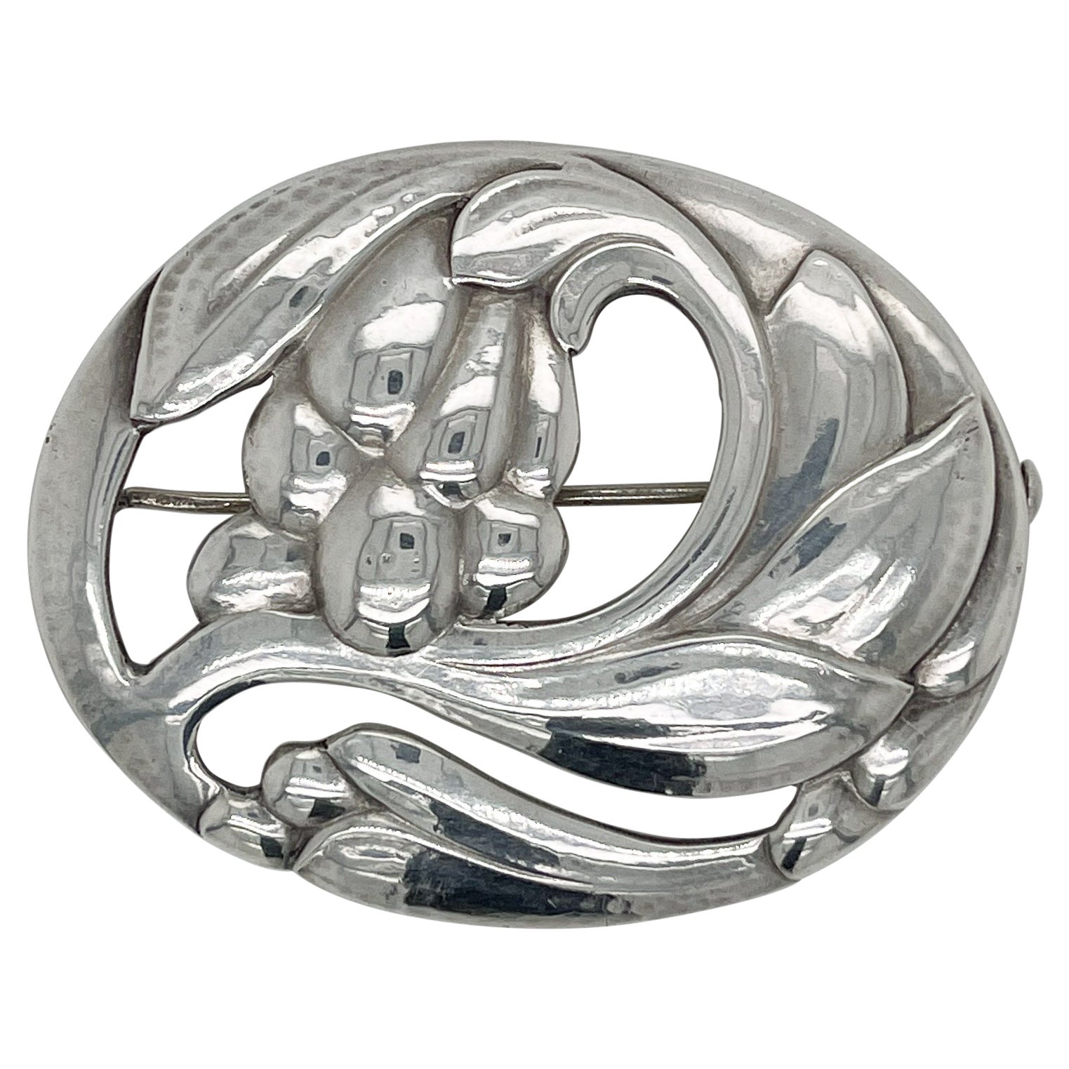 A fine antique Georg Jensen brooch or pin.

In sterling silver.

Model no. 65 with a floral motif.

Designed by Georg Jensen.

Together with its original box from Walter Muhke-Hofjuwelier Coblenz (Crown Jeweler).

Simply a wonderful brooch from one