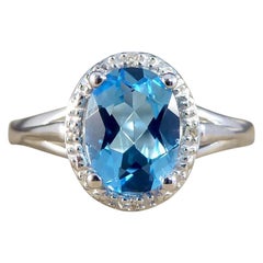 Oval Blue Topaz and Diamond Illusion Halo Cluster Ring in White Gold
