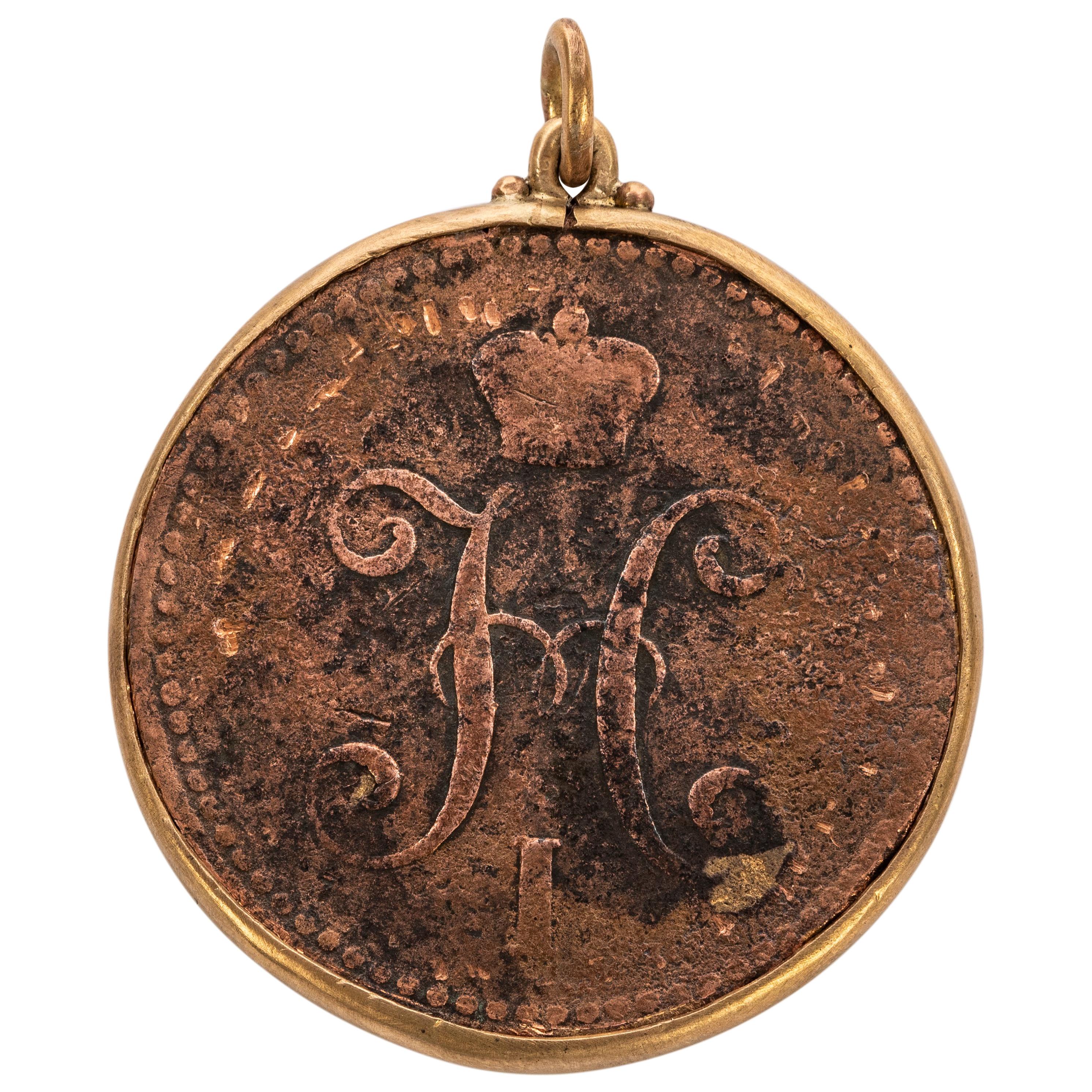 The rare Russia copper coin from the era of Tsar Nicholas I  (r. 1825-55), with the sovereign’s Cyrillic initial N I below a Romanov crown and the date of 1841 on one side, with Cyrillic lettering on the reverse. Mounted in silver gilt, chain not