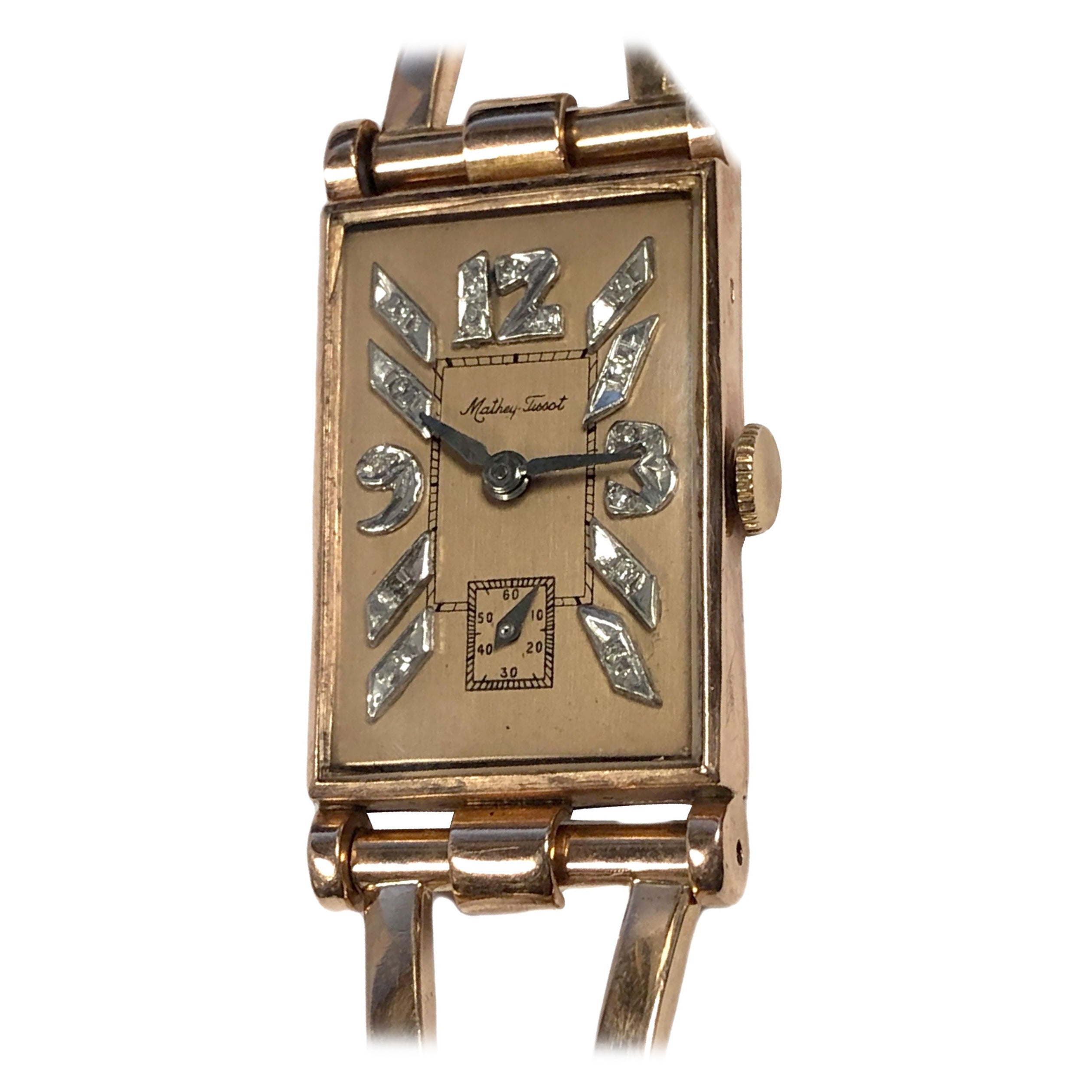 Circa 1940s Mathey Tissot Wrist Watch, 38 M.M. X 20 M.M. Rectangular 14K Rose Gold 2 piece case, 17 Jewel Mechanical Manual wind nickle lever movement, Rose Gold dial with Raised Diamond set White Gold markers.  1/2 inch wide 14k Rose Gold Link