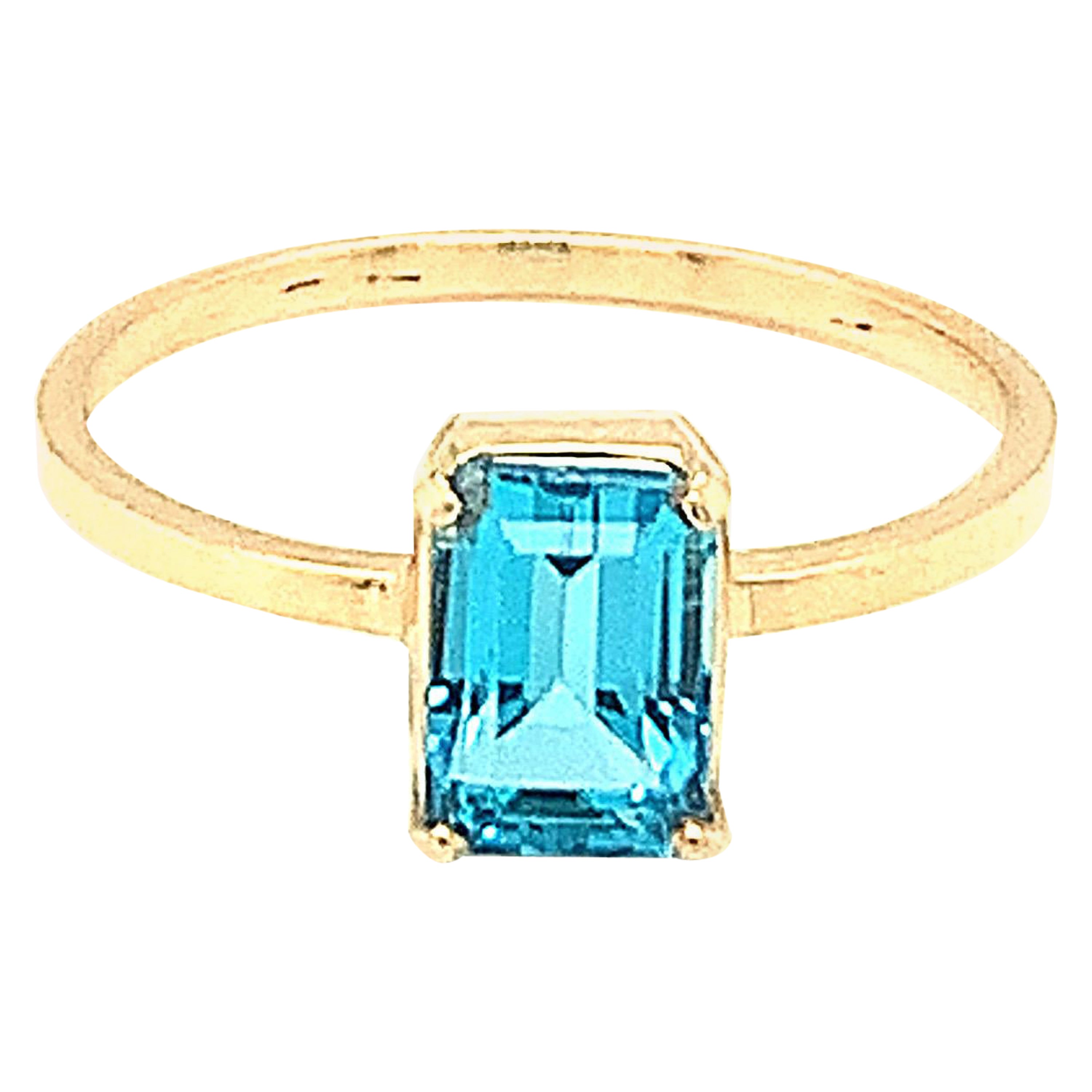 Anillo de oro amarillo de 14k con topacio azul talla baguette