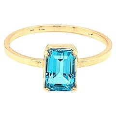 Anillo de oro amarillo de 14k con topacio azul talla baguette