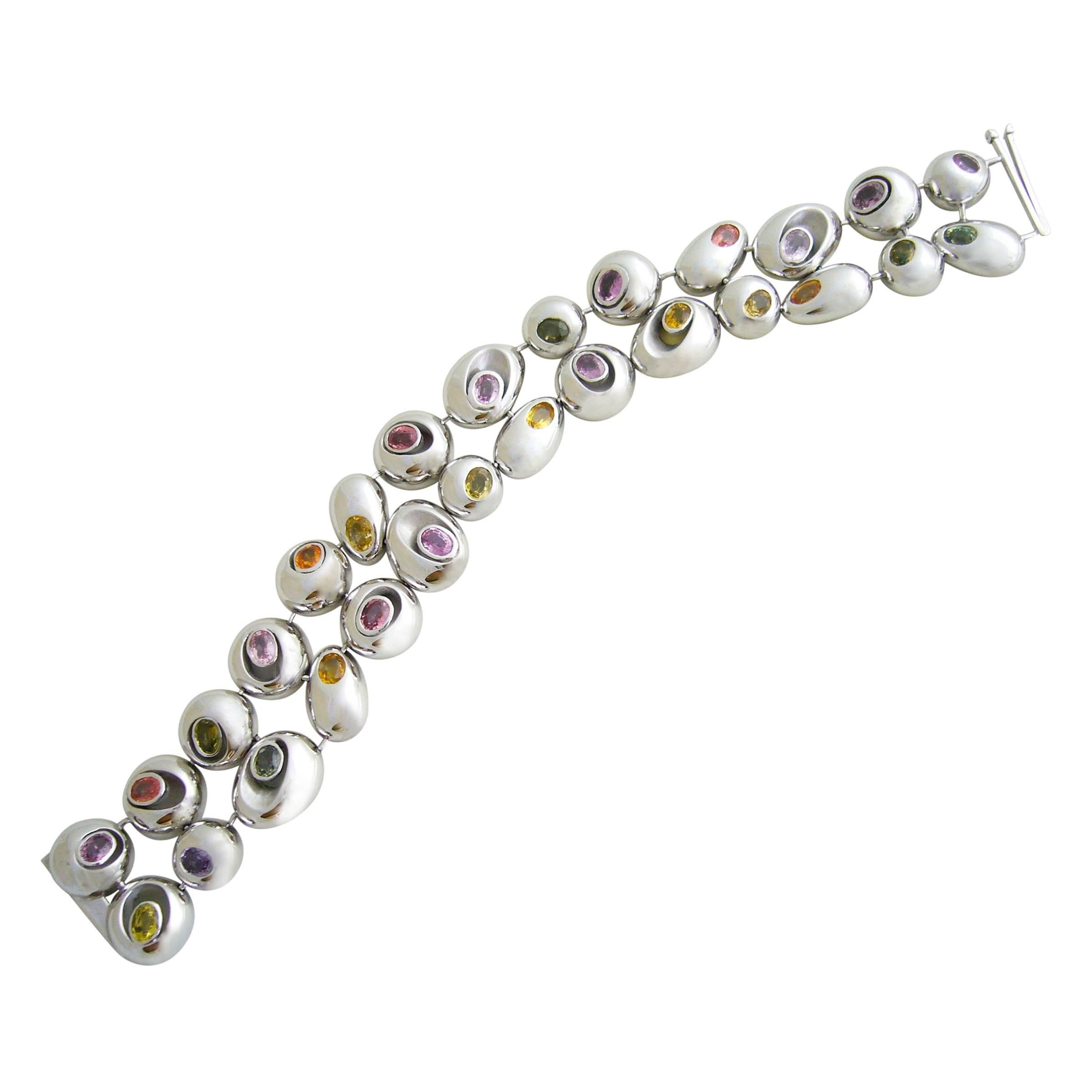 18k white gold and multicolored sapphire bracelet designed and created by Romain Saide, manufactured by Arnould Edition Paris, France. Saide was a designer for Arnould from 1988 thru 2009 and also a free lance designer for many exclusive brands of