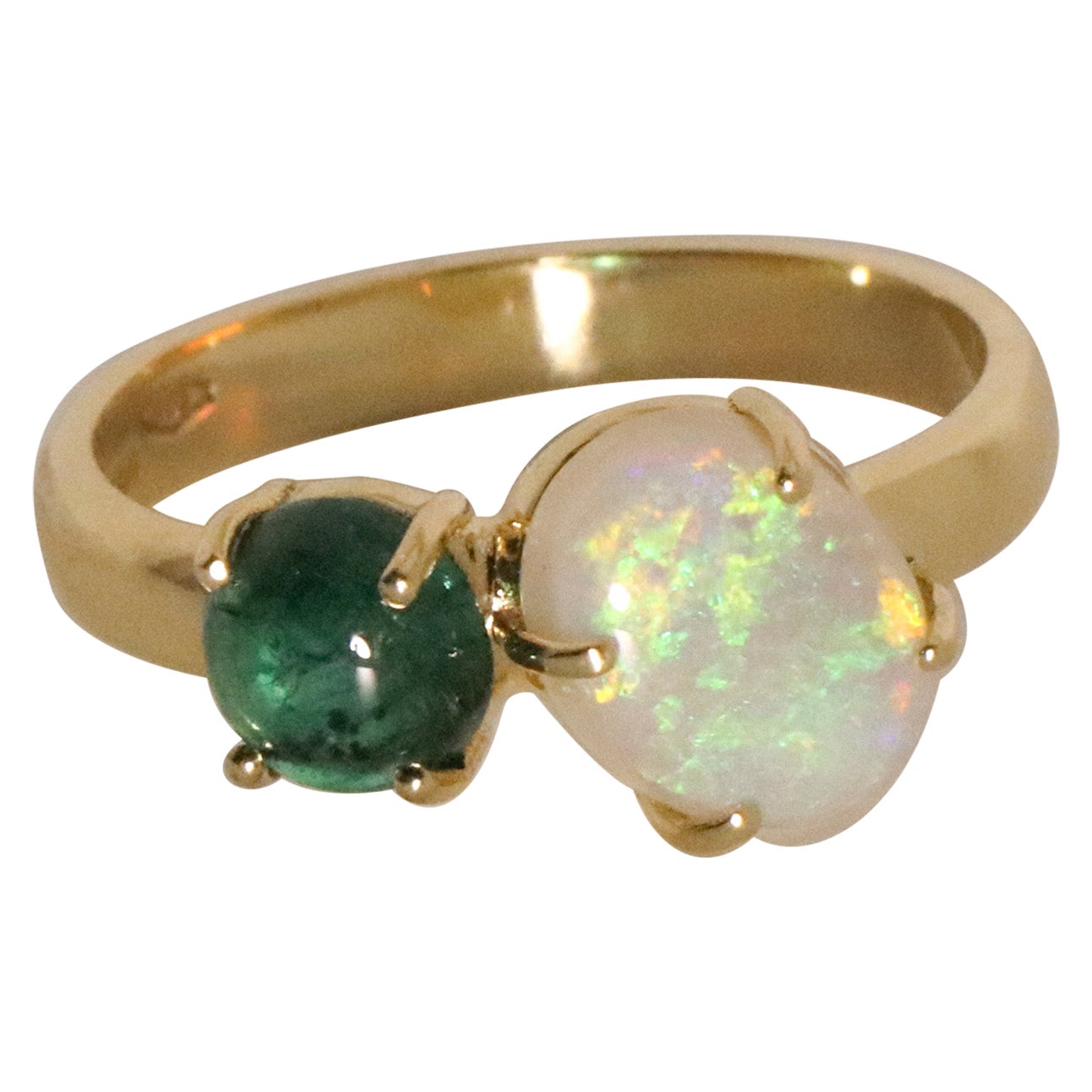 The Ines ring is made of 18 karat yellow gold and features a round cabochon cut natural emerald around 0.8 carats, diameter 5.9, depth 3.05 mm and an high quality oval cabochon cut Australian opal around 1.4 carats, 9.21*7.1*3.4 mm. The total weight