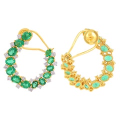 Boucles d'oreilles cerclées en or jaune 14k avec un diamant de couleur HI et une émeraude ovale.