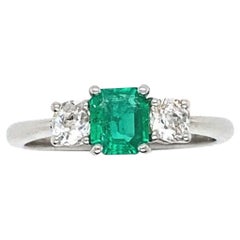 Anillo de compromiso de platino con esmeralda colombina y diamantes de 0.43 quilates y tres piedras