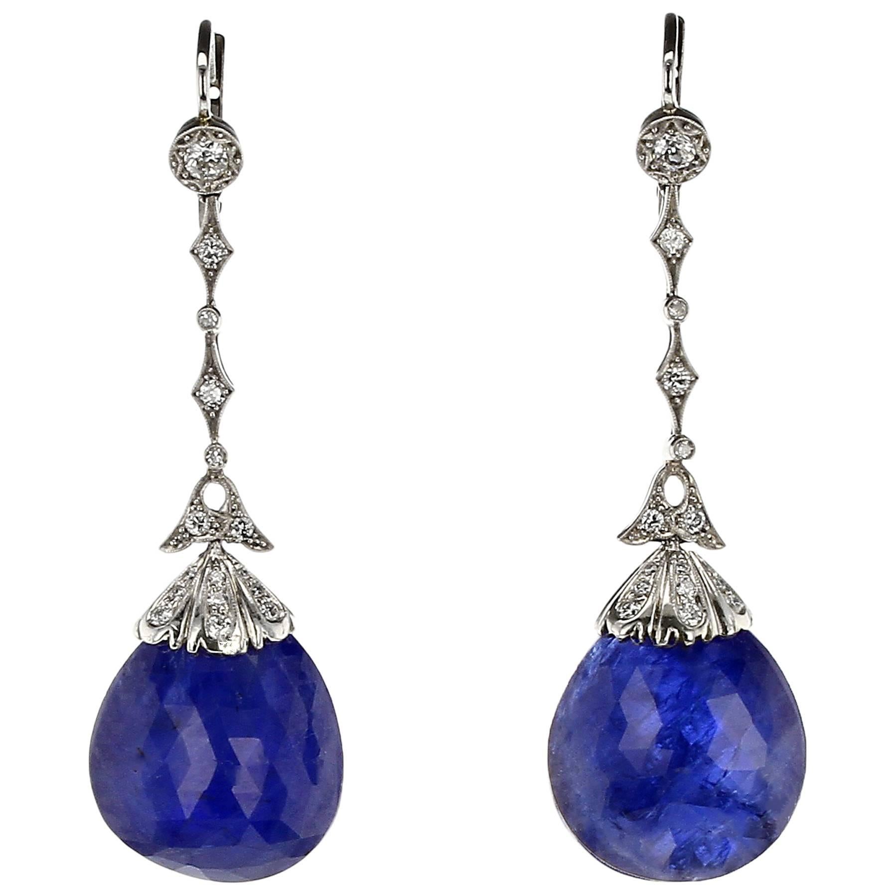 A stunning and bold pair of natural, no-heat sapphire briolette-cut drops suspended from a diamond-studded cap and mounting with alternating star shape and round bezel-set diamonds, with milgrain work. The two sapphires weigh an approximately