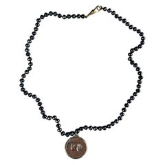 Médaille du Sacré-Cœur en argent et rubis  Collier ras du cou en perles noires J Dauphin