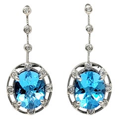 Boucles d'oreilles pendantes en or blanc avec topaze bleue de taille ovale de 6,32 carats et diamant.