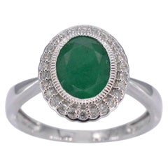 White gold entourage ring with diamonds and emerald